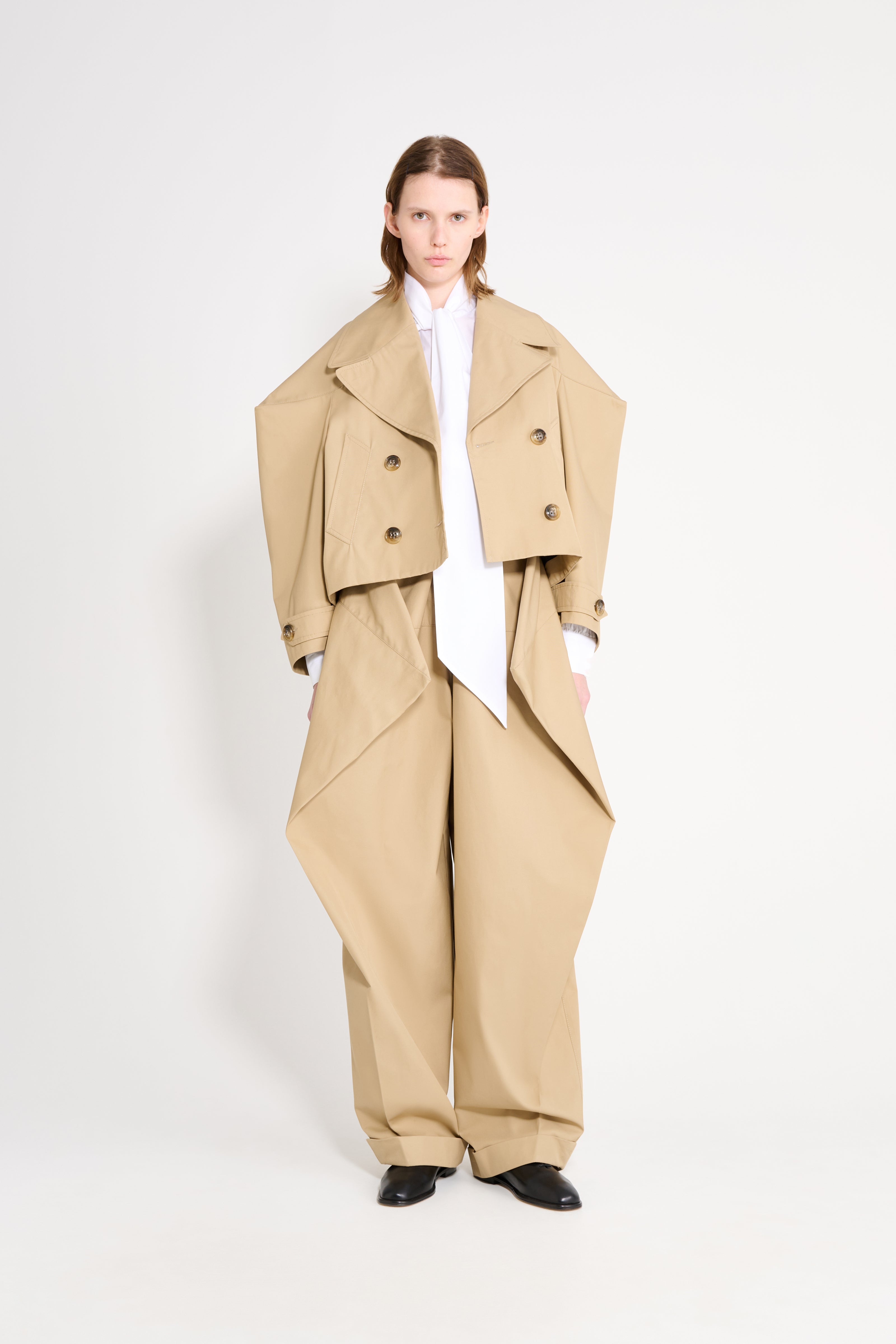 Person wearing a beige outfit with a white background
