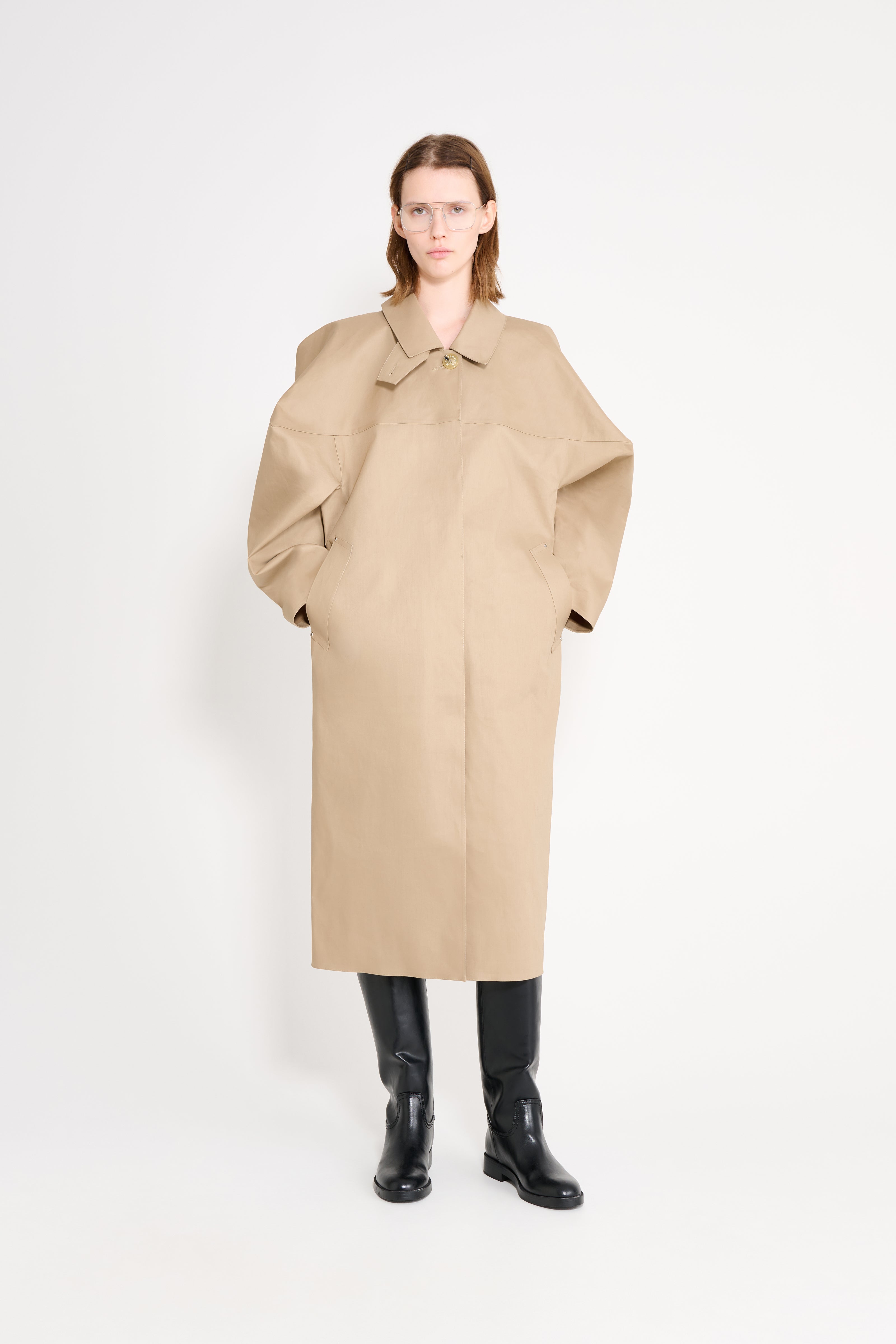 Woman wearing a beige coat on a white background