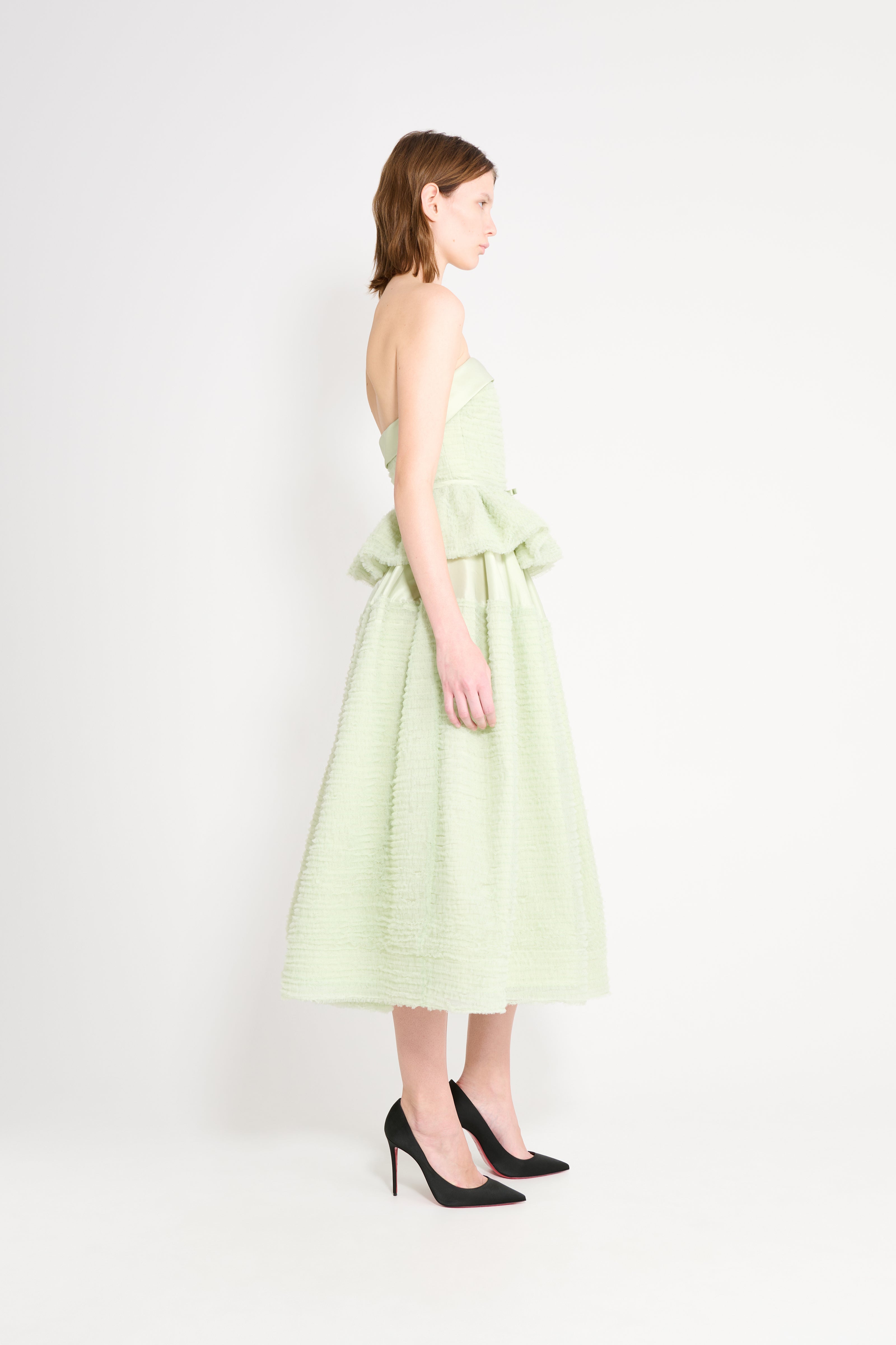 Woman wearing a light green dress on a white background