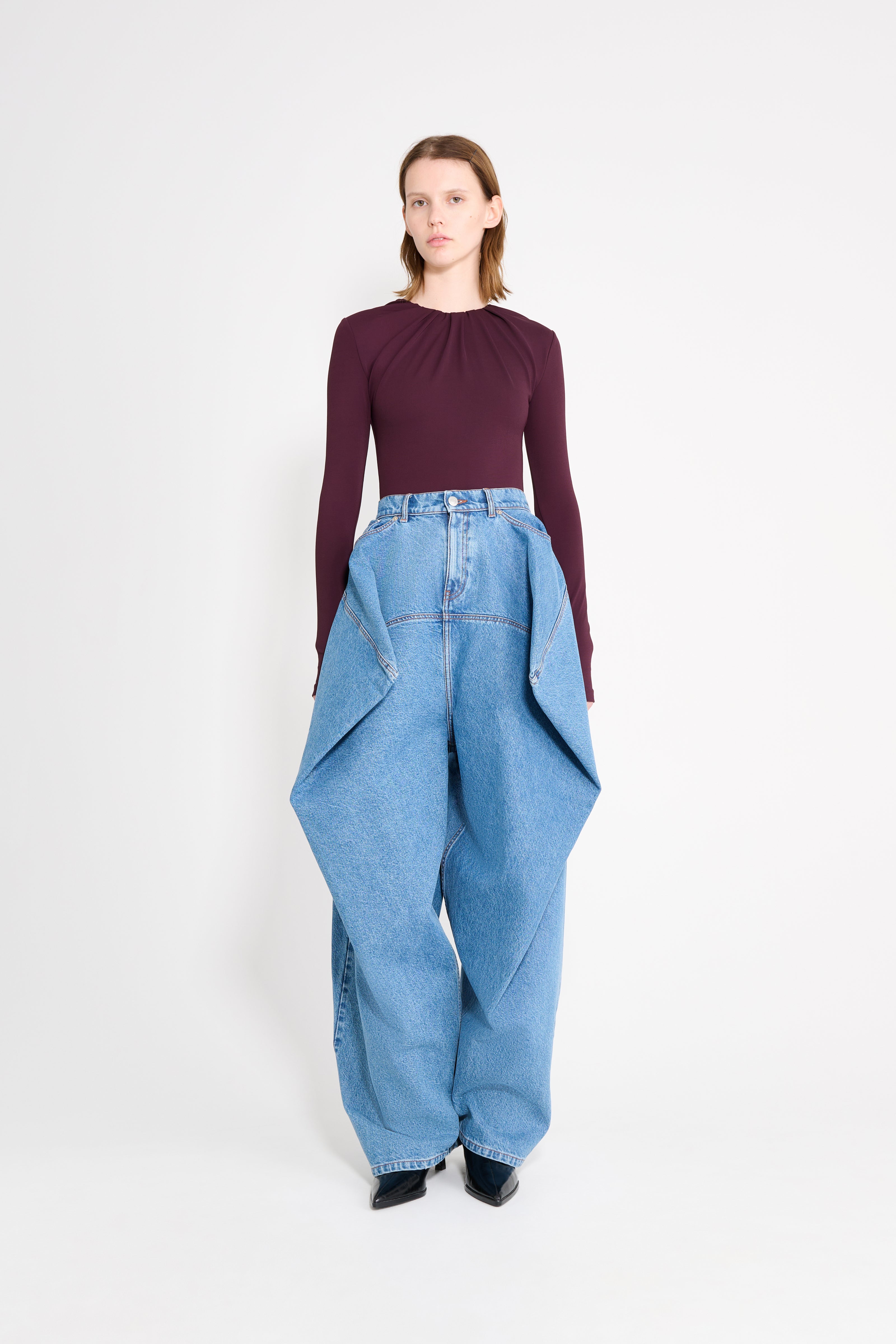 Model wearing a burgundy drape body with jeans.