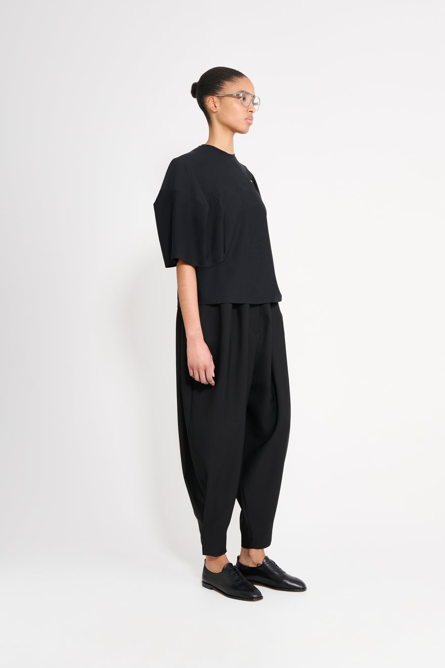 Person wearing a black outfit on a white background