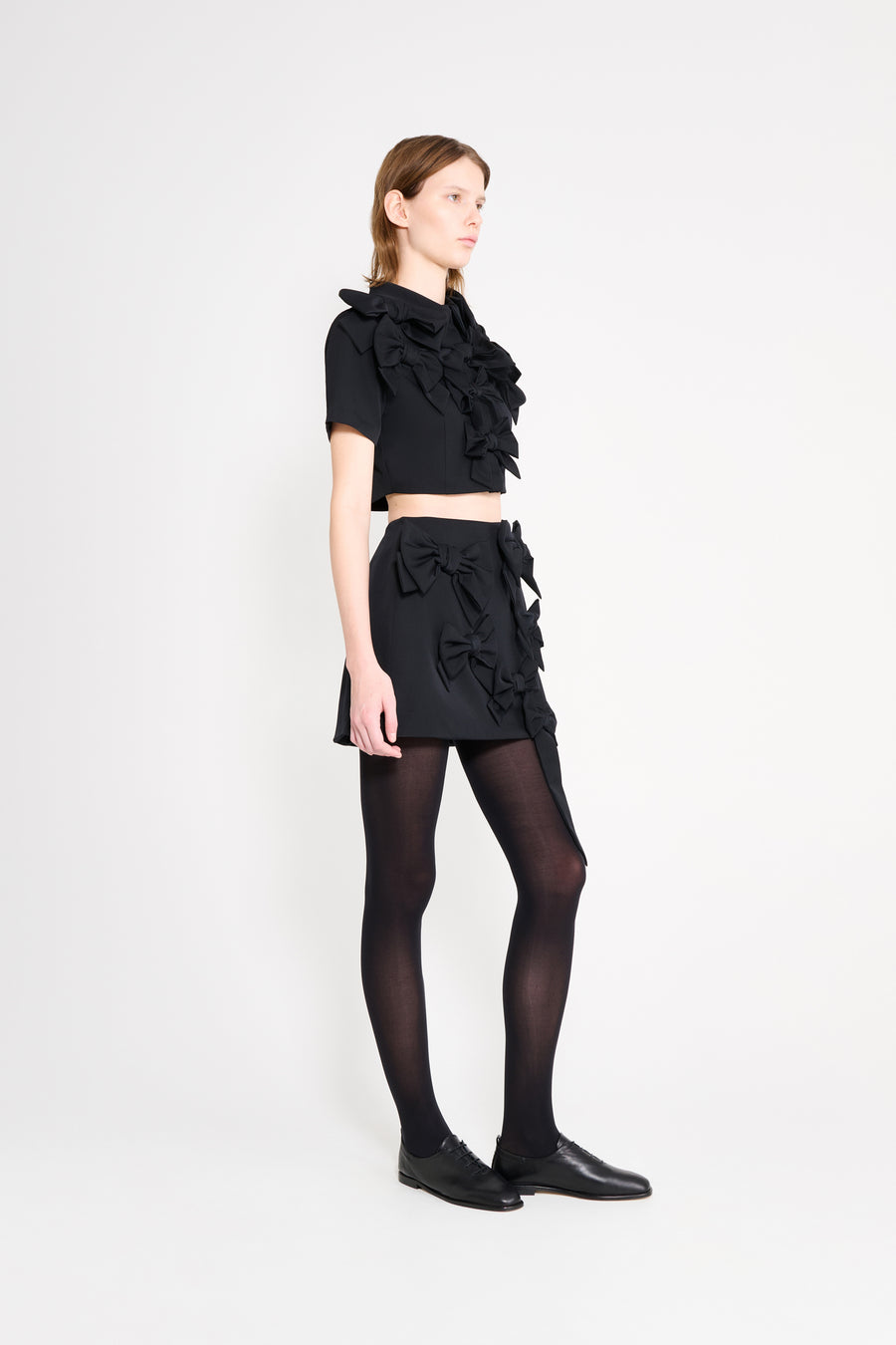 The wool top features the seasonal bow bouquet technique, where timeless elegance meets refined craftsmanship in a seamless fusion of sophistication and grace