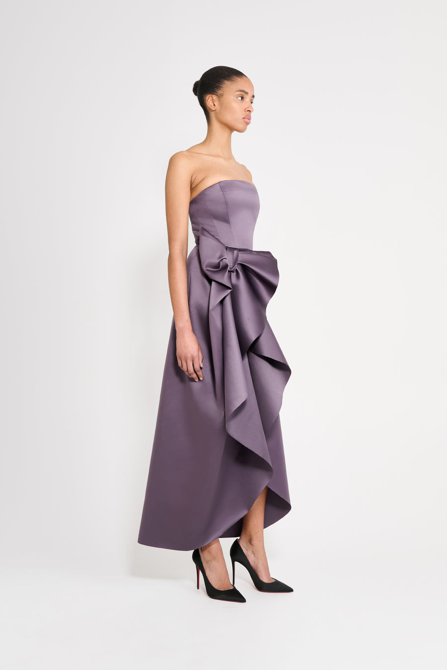 Model wearing a long purple dress on a white background.