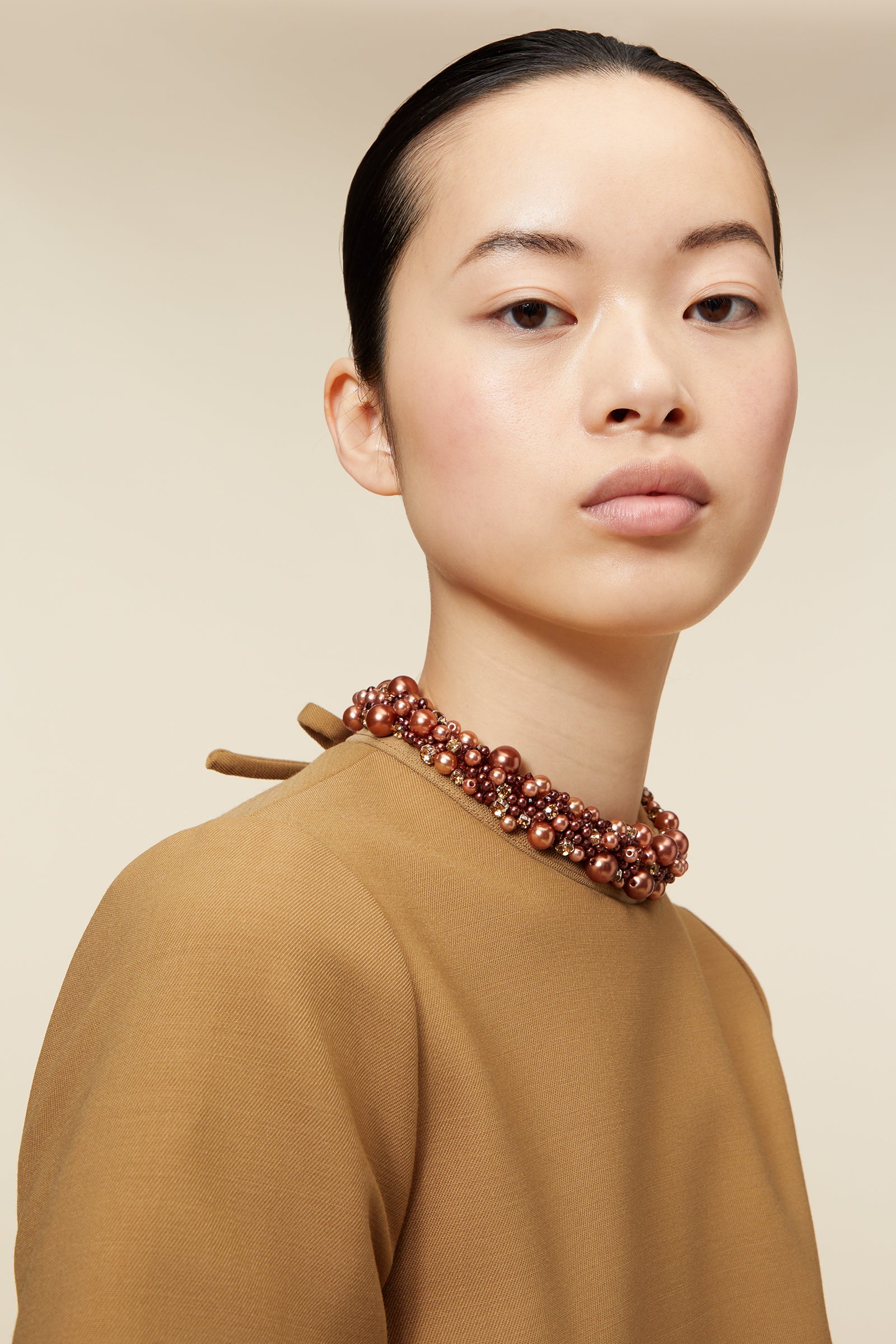 Elegant mustard-colored dress with beaded trim on pockets and collar, featuring short sleeves and a straight silhouette.