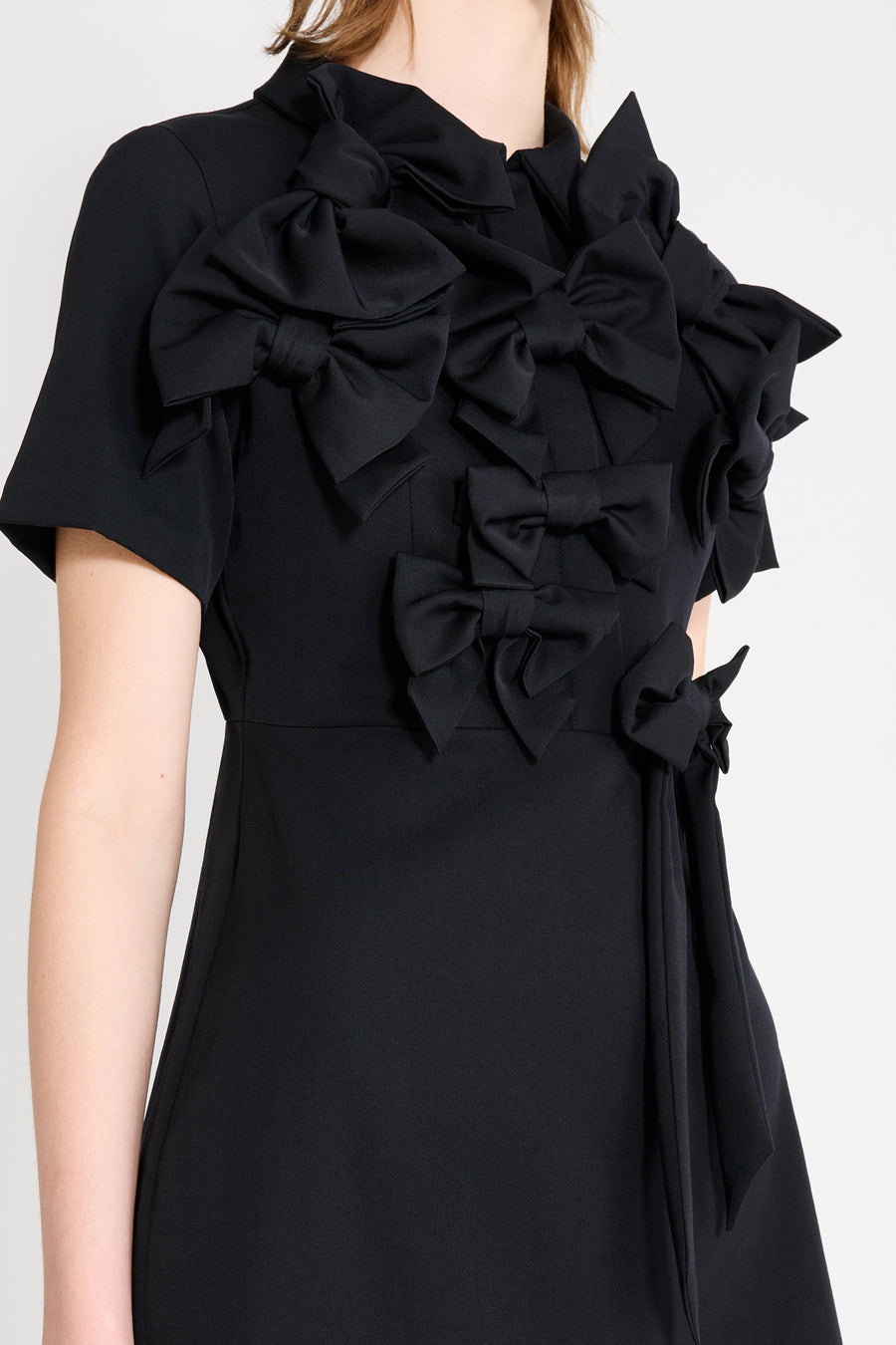 The wool dress features the seasonal bow bouquet technique, where timeless elegance meets refined craftsmanship in a seamless fusion of sophistication and grace