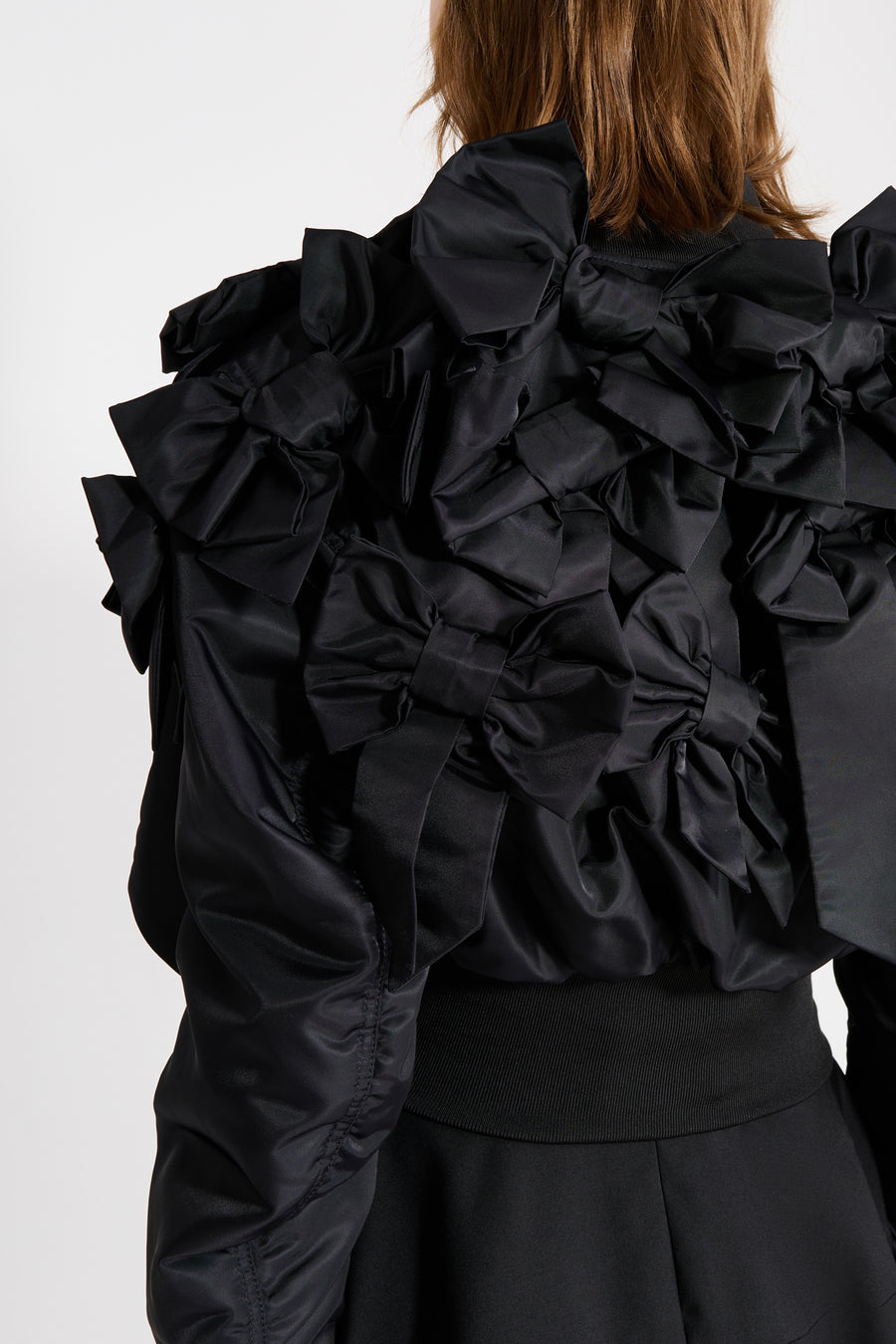 The bomber inspired by the haute couture "action dolls" collection reinvents playful sophistication, merging the volume of a puffer design with a seasonal bow bouquet technique