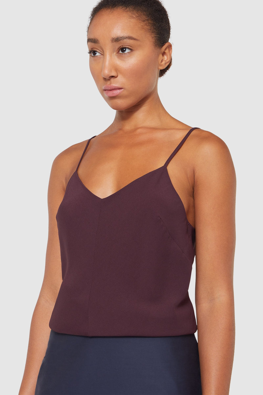 Dark burgundy camisole top featuring thin straps and a flattering V-neckline, crafted from a smooth, lightweight fabric.