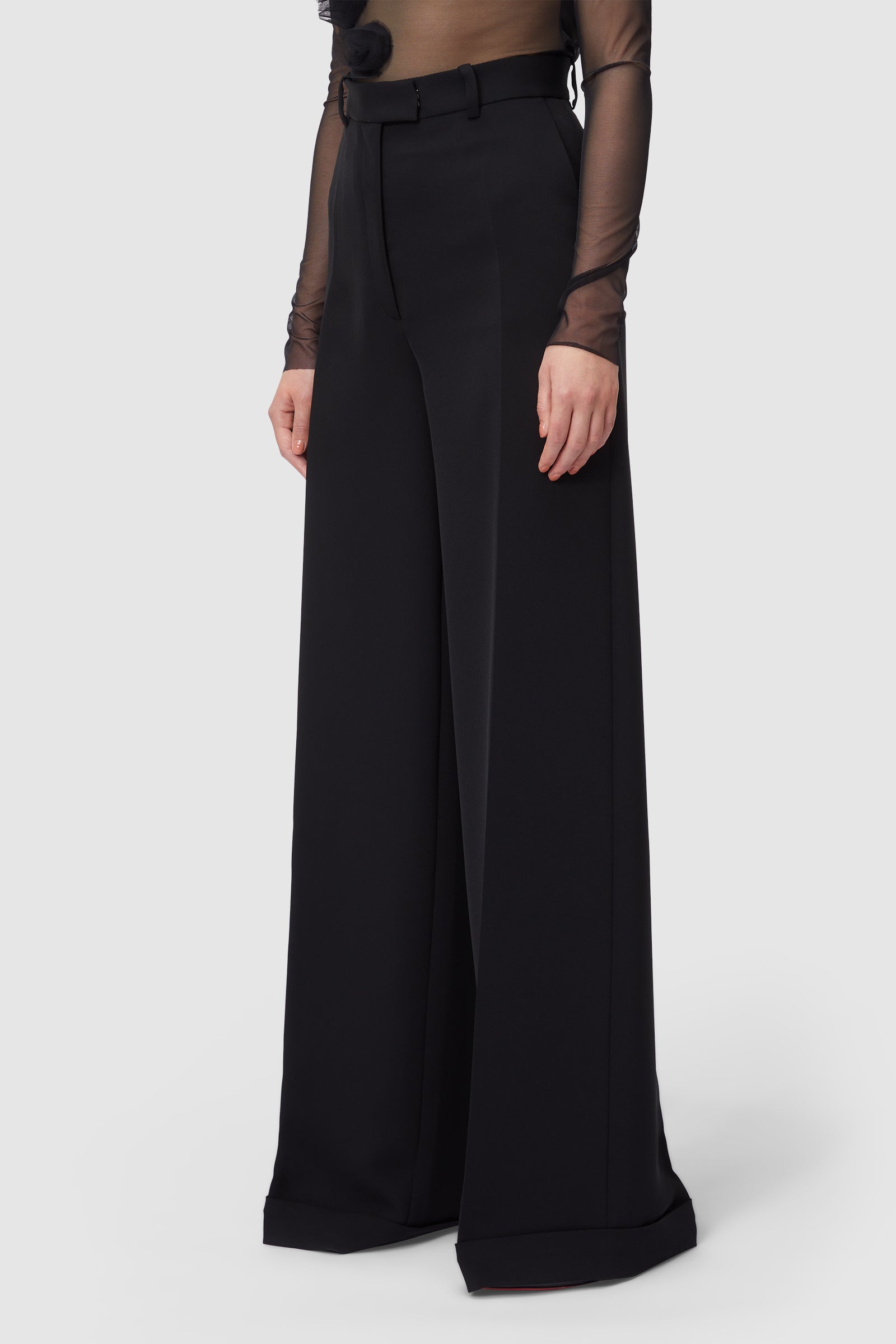 Elegant wide-leg black trousers with a high-waist fit and sleek, tailored detailing, perfect for a sophisticated look.