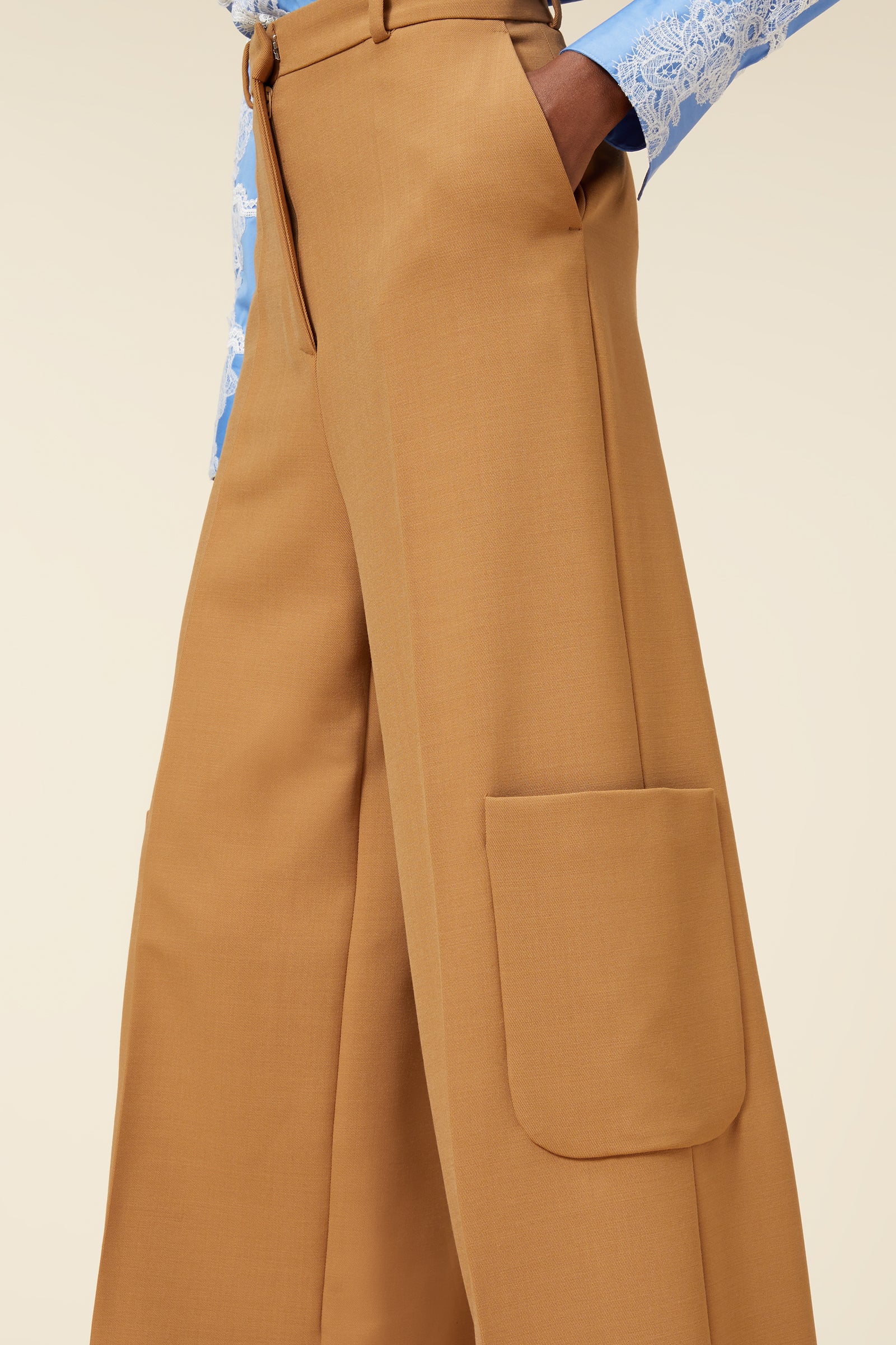 High-waisted camel wide-leg trousers with tailored pockets, perfectly paired with a light blue lace-detailed blouse.