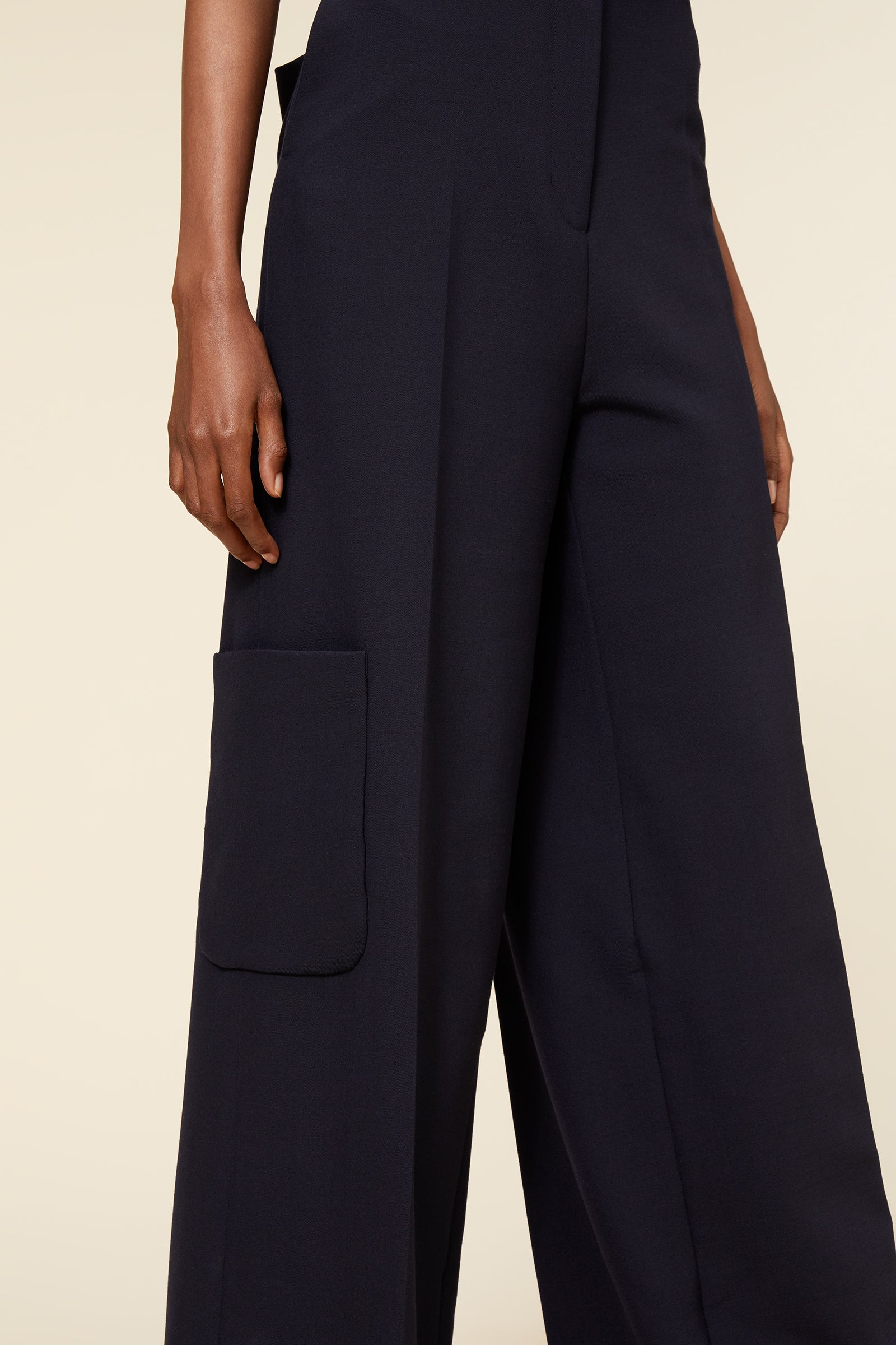 Wide-leg black pants featuring a sleek, tailored fit and a distinct side pocket, crafted from high-quality fabric.