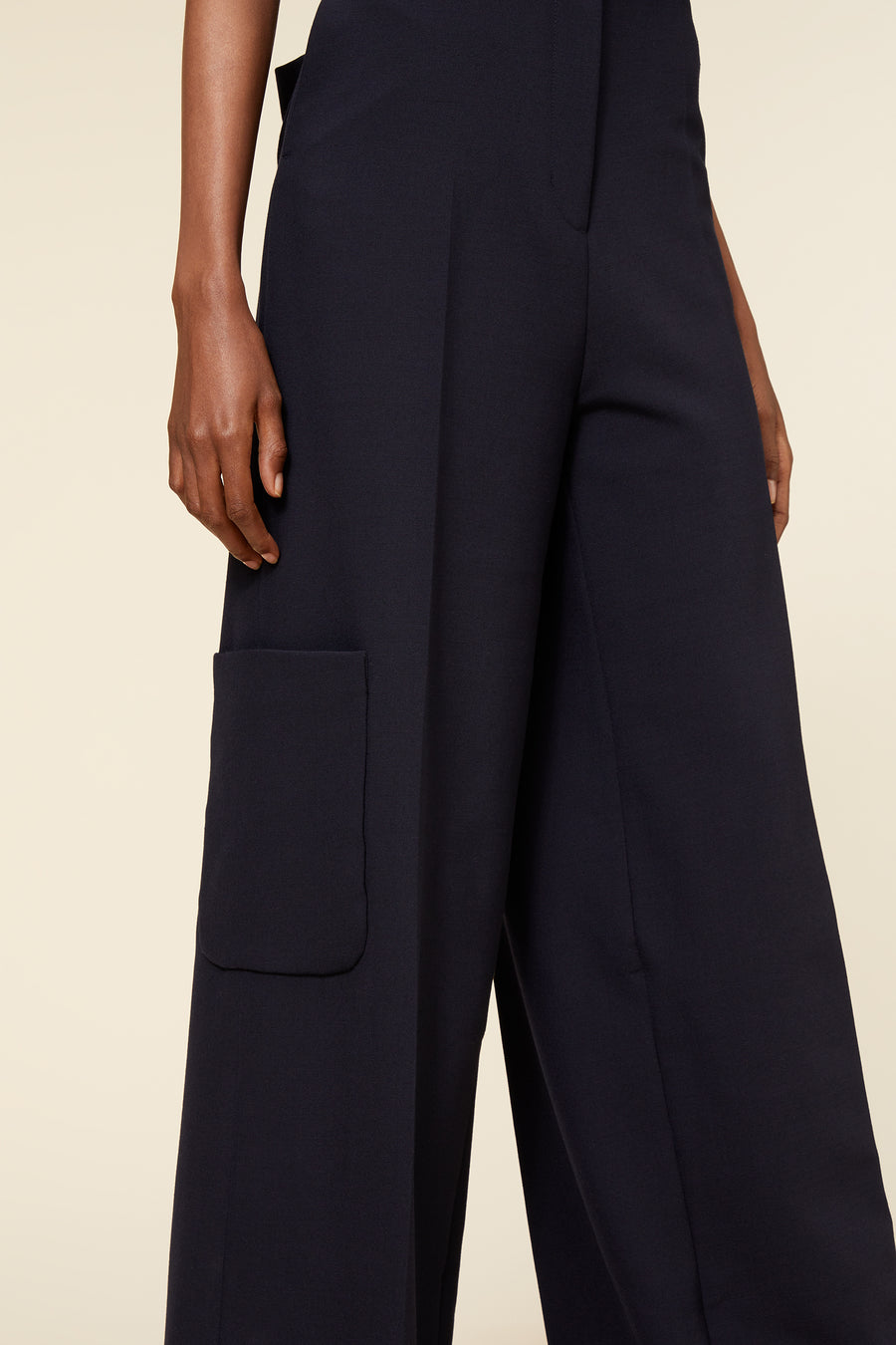 Wide-leg black pants featuring a sleek, tailored fit and a distinct side pocket, crafted from high-quality fabric.