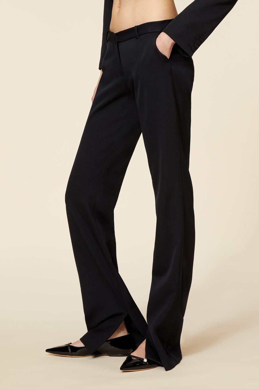 Tailored black trousers in a sleek, wide-leg design paired with polished patent leather pointed-toe flats.