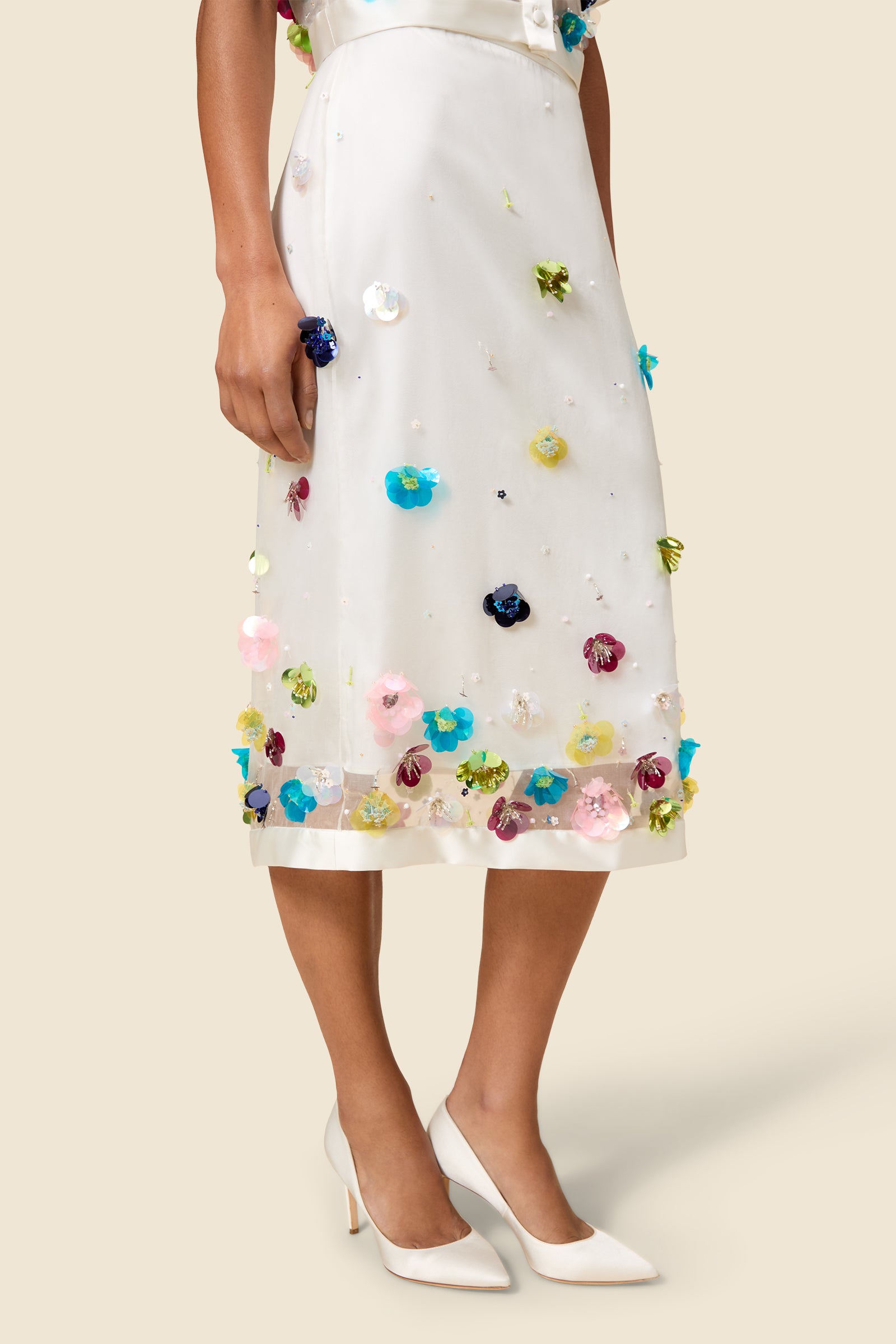 With hand-applied paillettes and crystals on silk organza featuring the satin edges, the skirt transforms classic floral embroidery into a modern piece