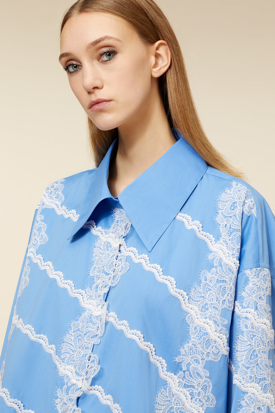 Blue blouse with intricate white lace embroidery patterns, featuring a wide collar and detailed design.
