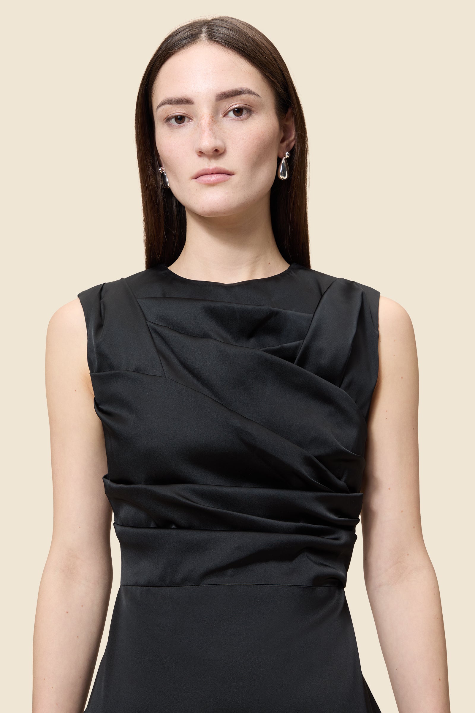 The meticulously placed pleats and stretch satin define the elegance of the dress, reflecting classic haute couture craftsmanship with a modern edge