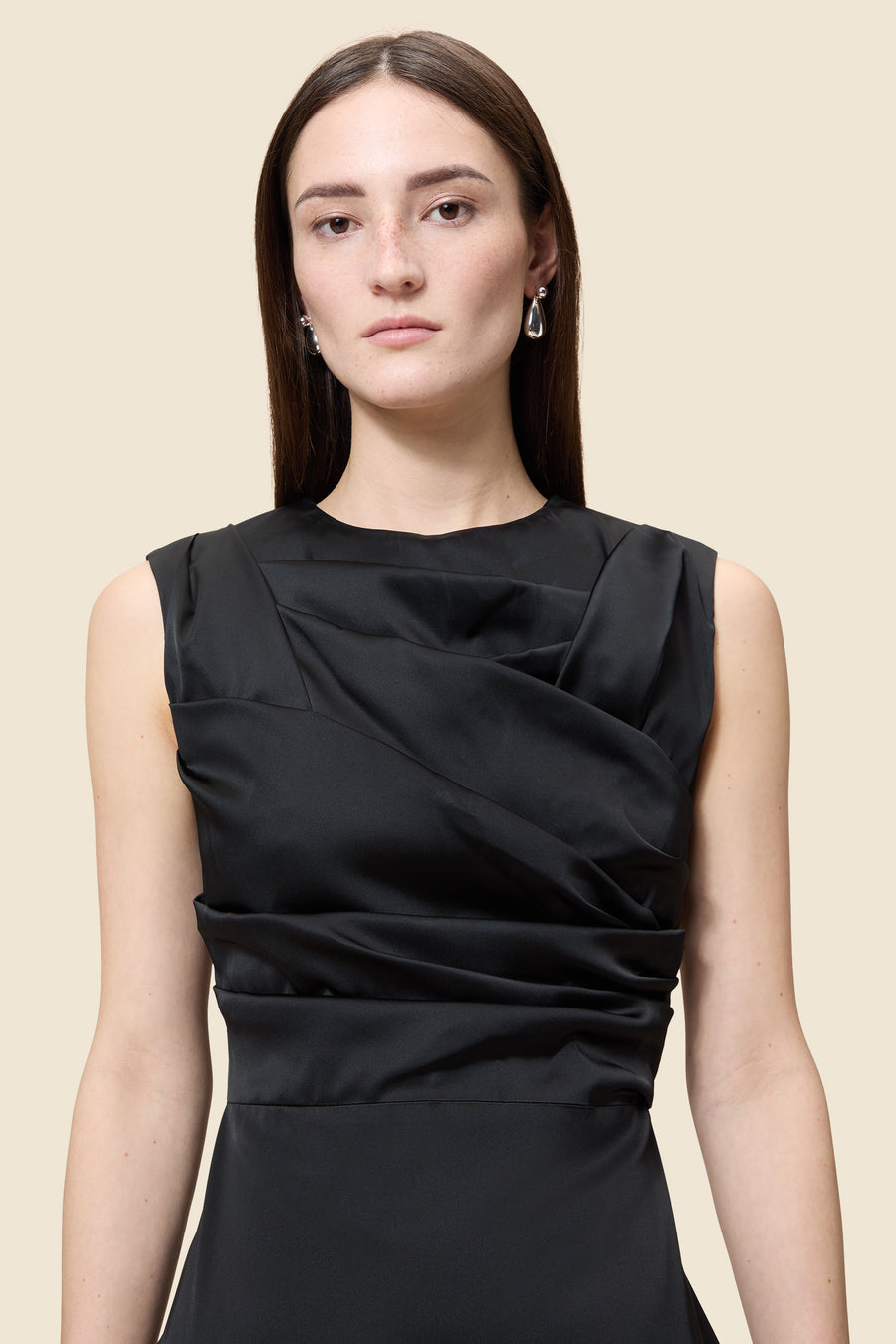 The meticulously placed pleats and stretch satin define the elegance of the dress, reflecting classic haute couture craftsmanship with a modern edge