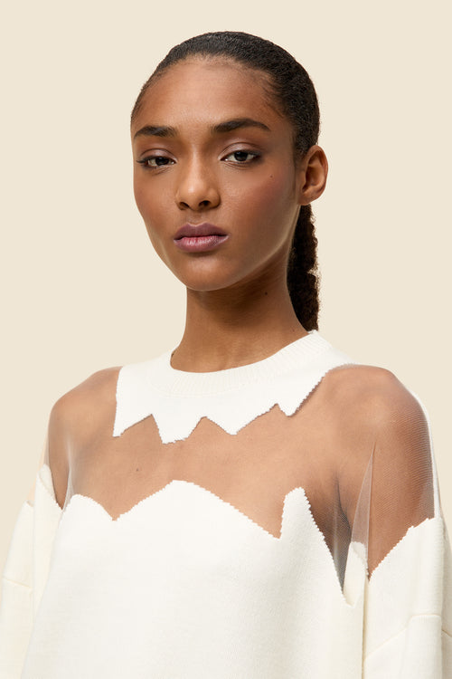 The knitwear, inspired by viktor&rolf's scissorhands, is crafted with 100% merino wool and showcases intricate holes knitted with transparent yarn in a jacquard technique