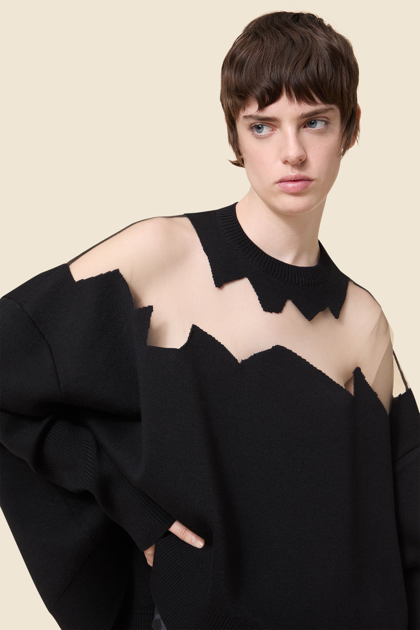 The knitwear, inspired by viktor&rolf's scissorhands, is crafted with 100% merino wool and showcases intricate holes knitted with transparent yarn in a jacquard technique