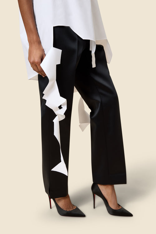 Modern black and white geometric pattern pants paired with elegant black high heels against a neutral background.