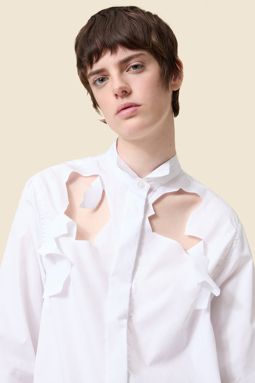 Chic tailored black tuxedo jacket paired with a crisp white shirt, featuring uniquely styled cut-out black trousers.