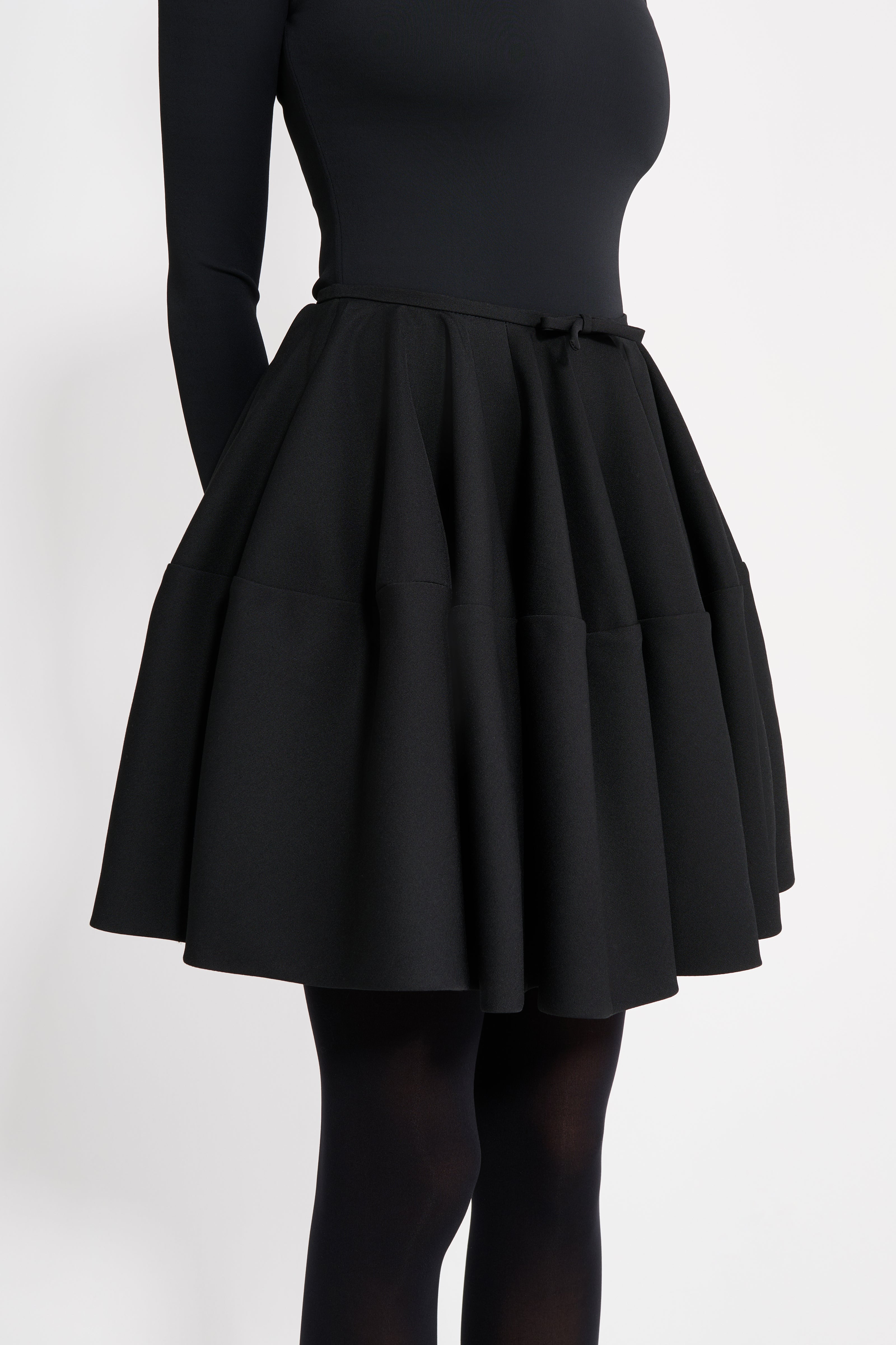 Black skirt worn by a person on a white background