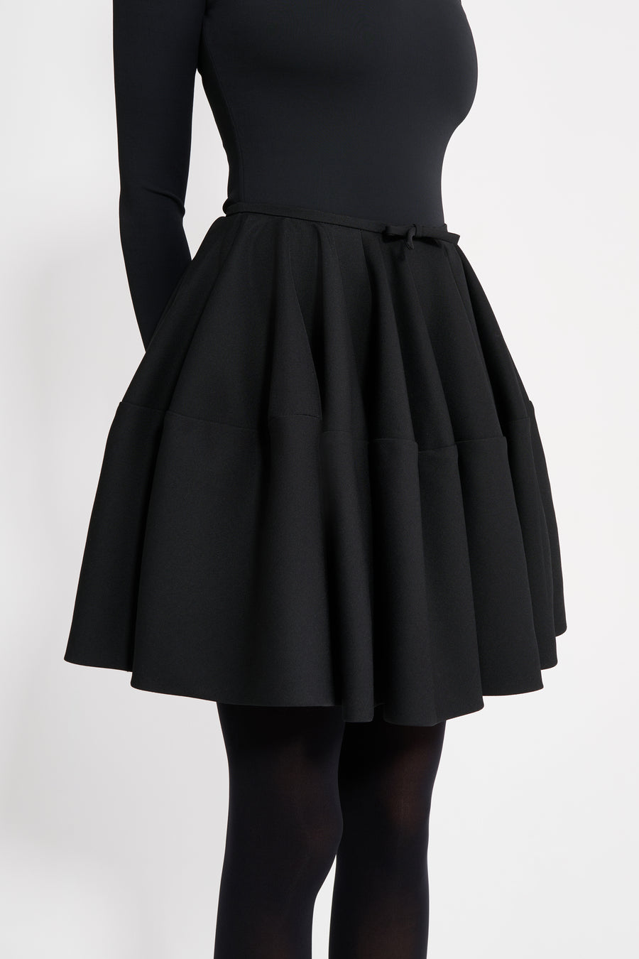 Black skirt worn by a person on a white background