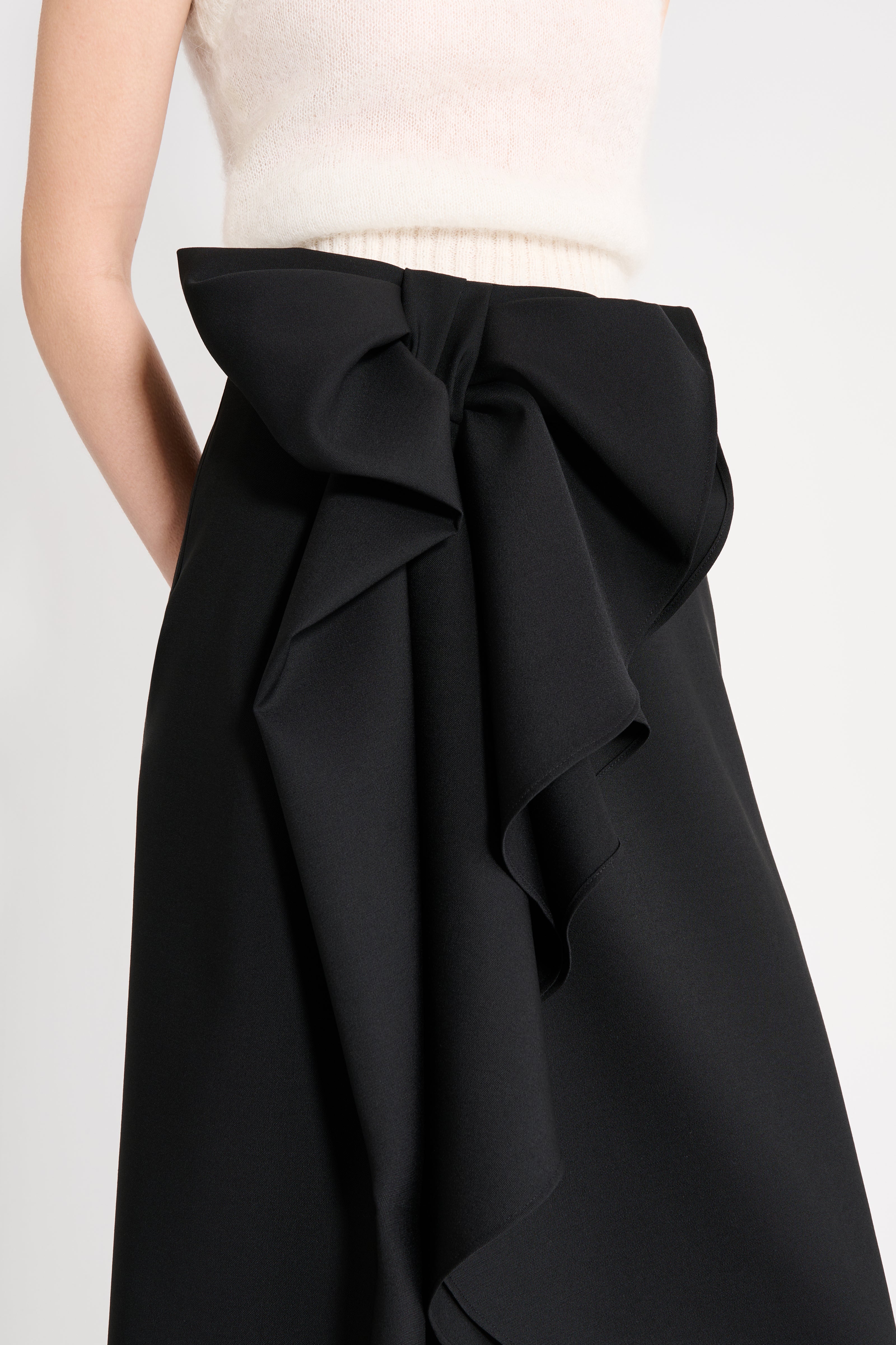 Close up on a model wearing a black wool skirt.