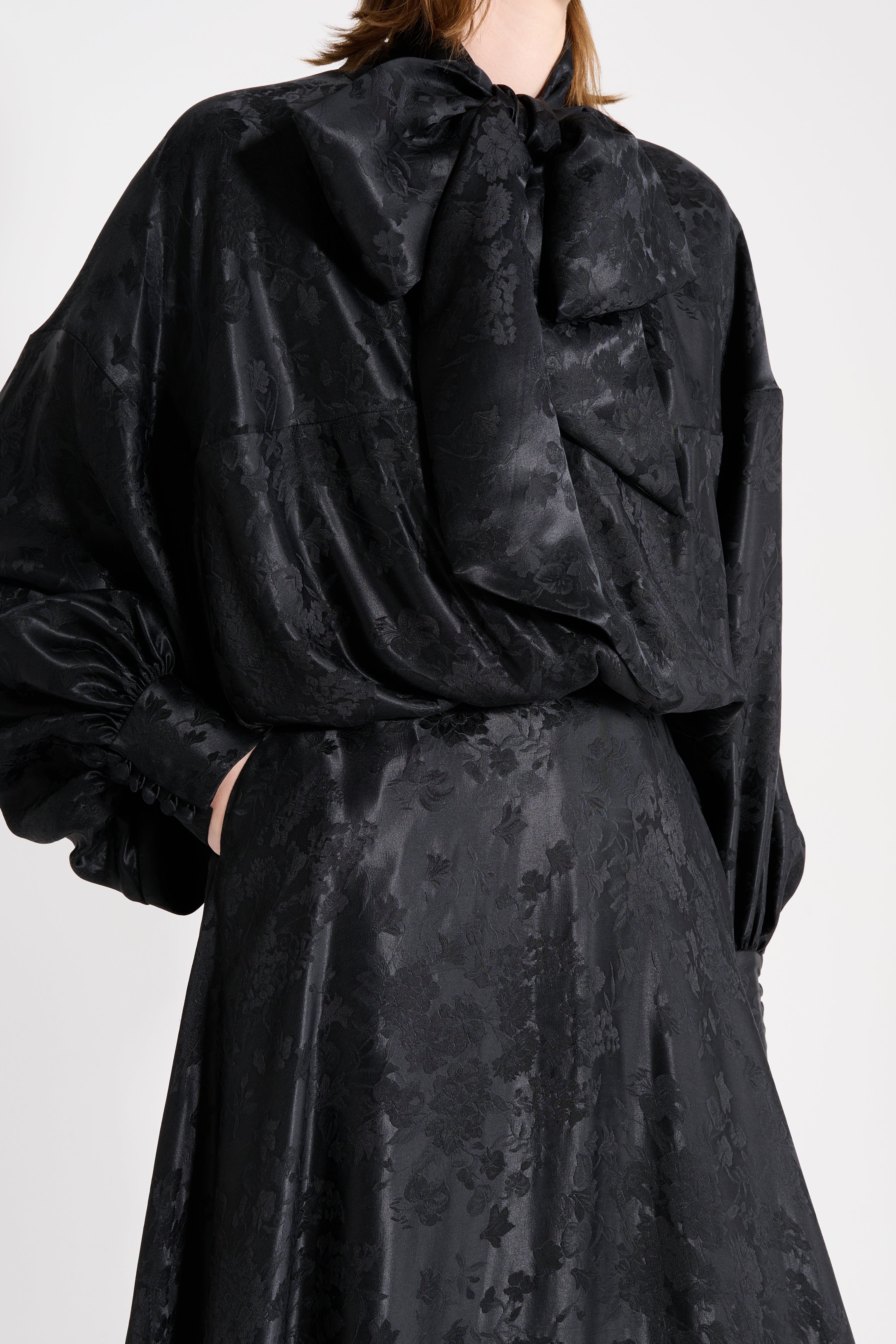 Black textured blouse and skirt set on a plain background