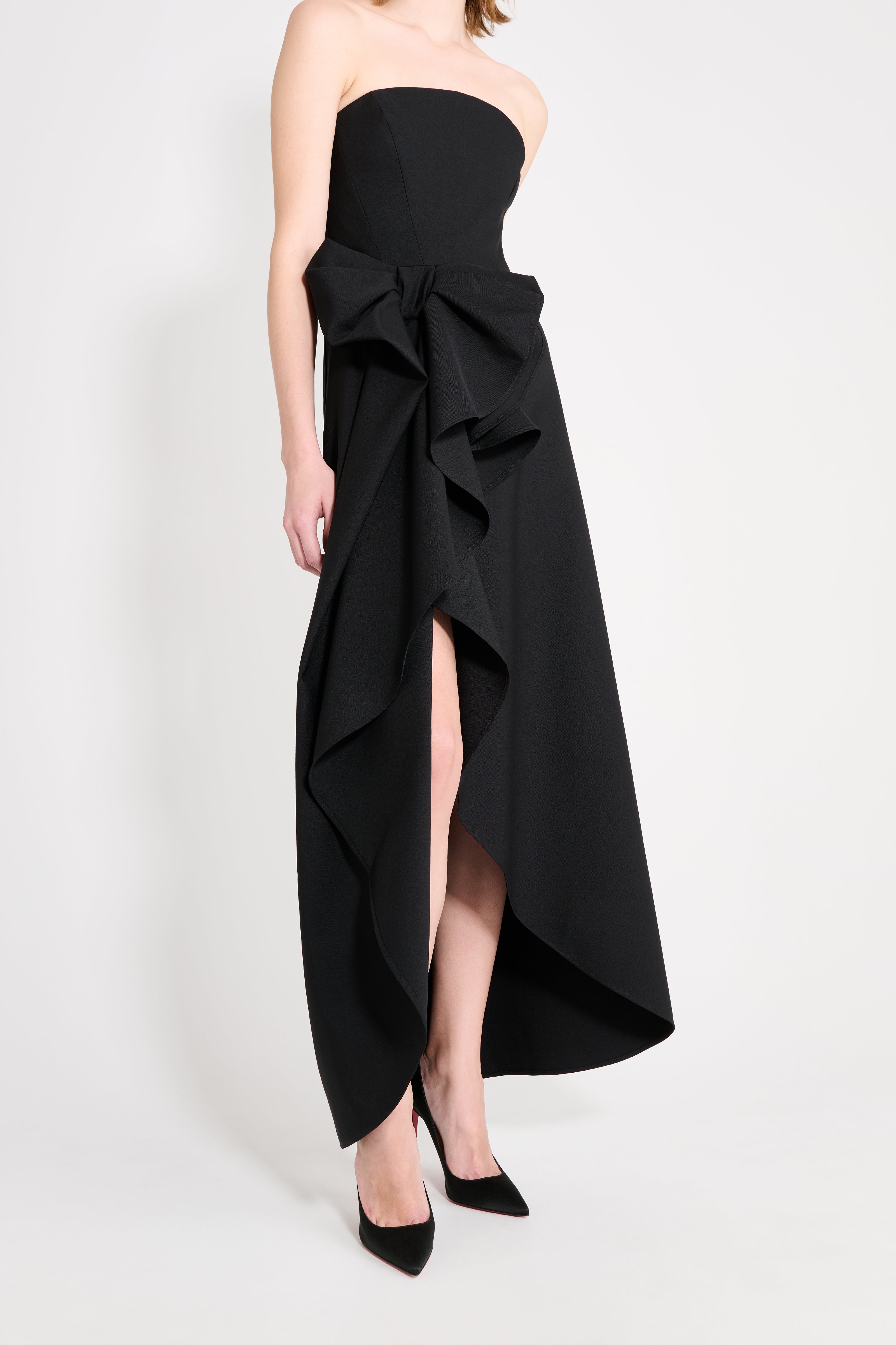 Black strapless gown with ruffled design on a white background