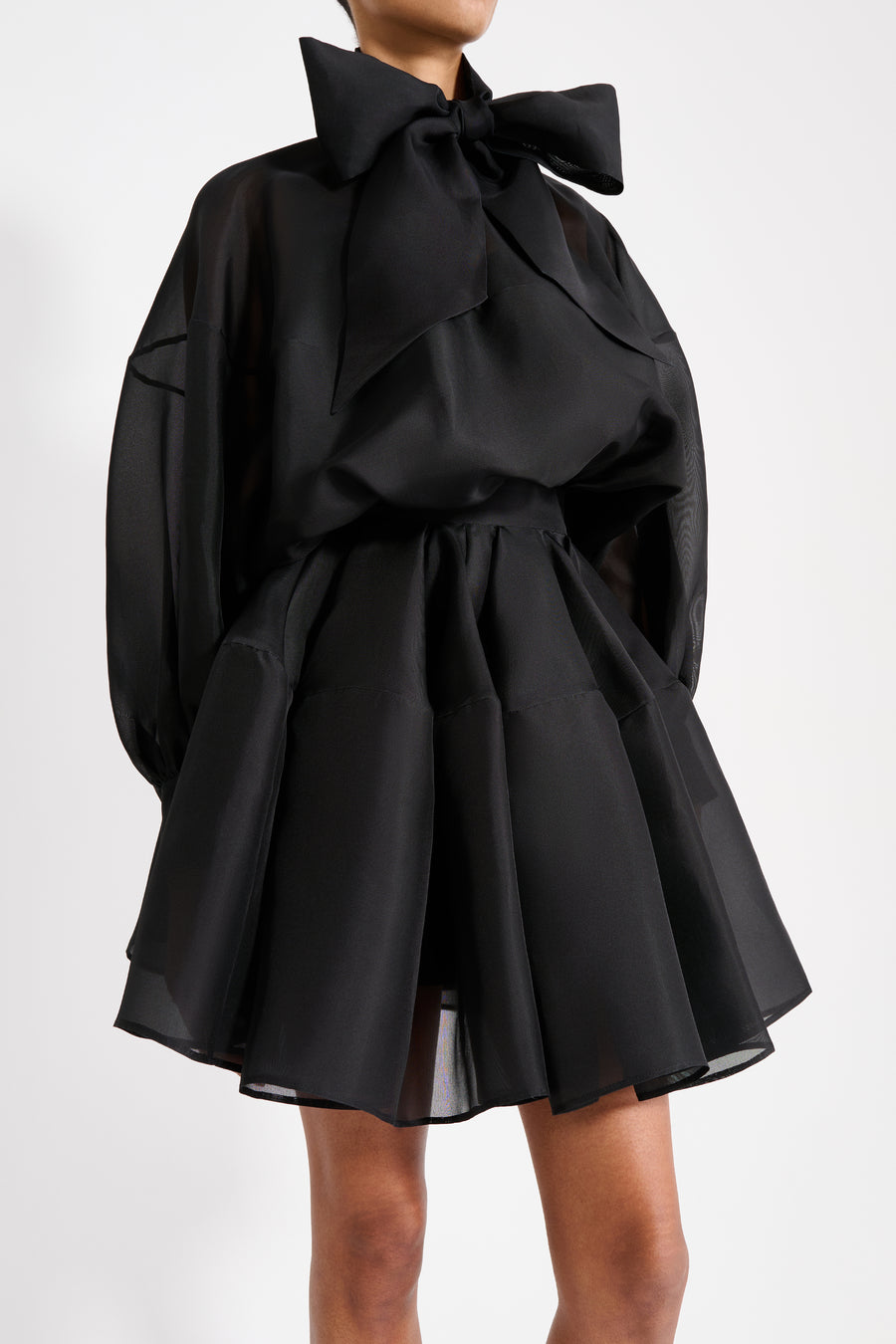 Black dress with a large bow detail on a white background