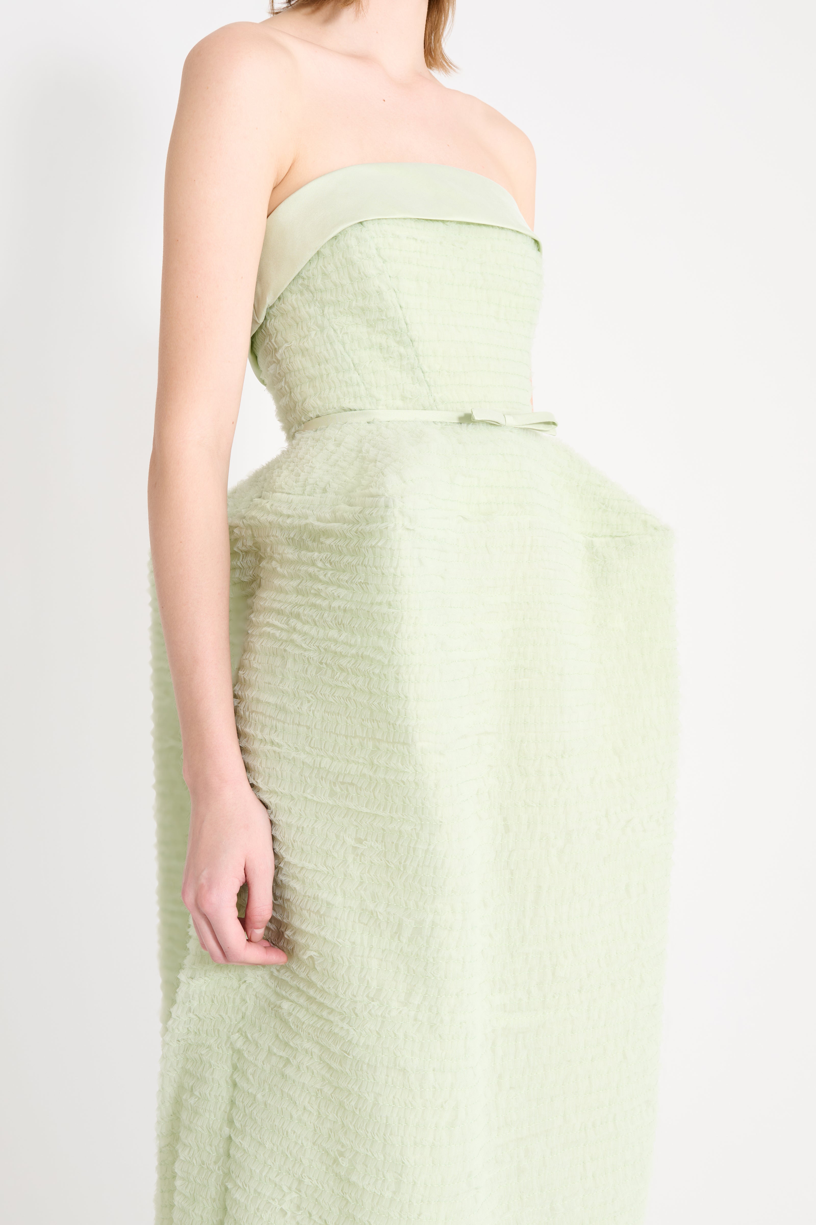 Light green strapless dress on a plain background