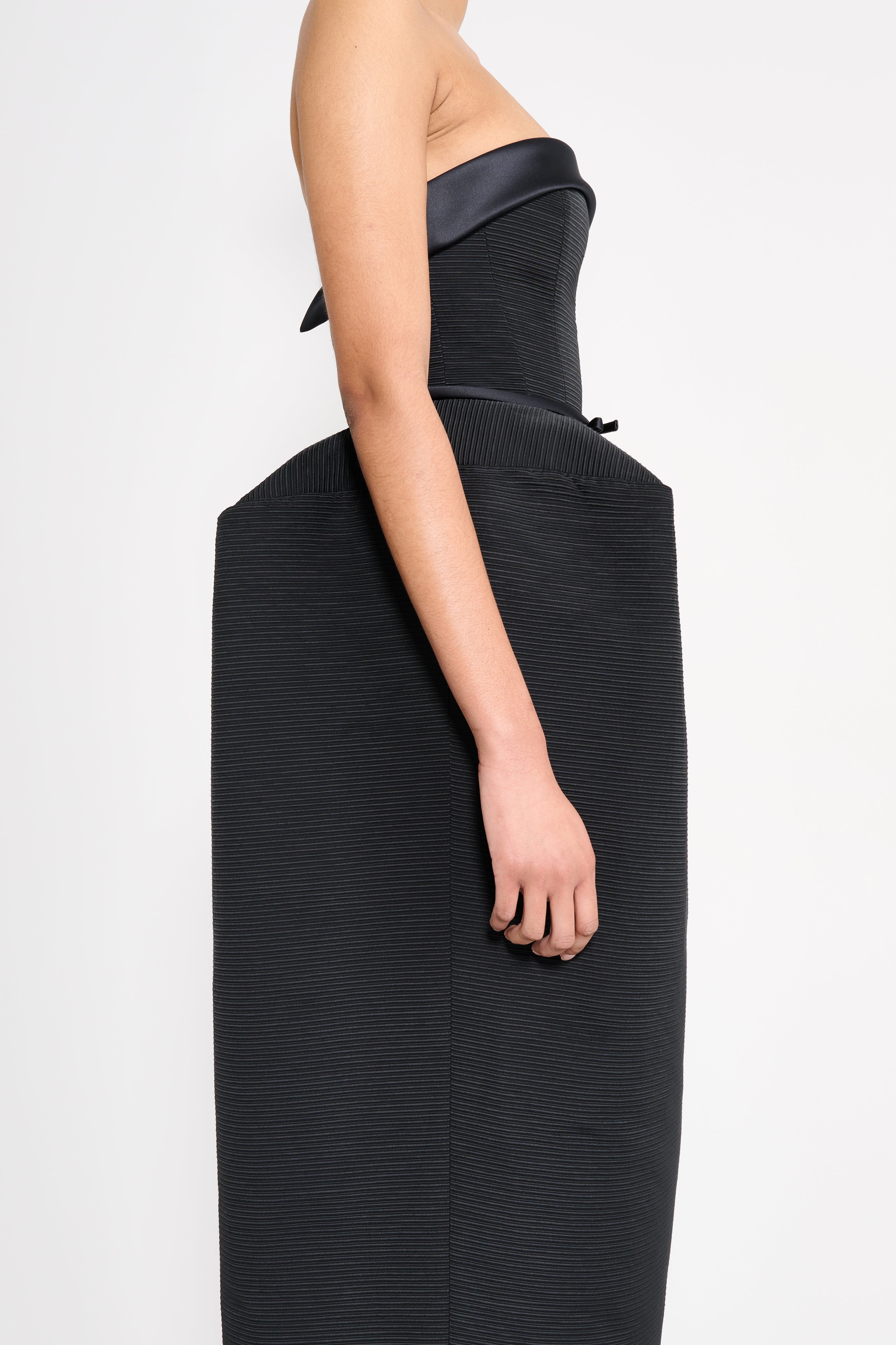 Black strapless dress with textured fabric on a white background