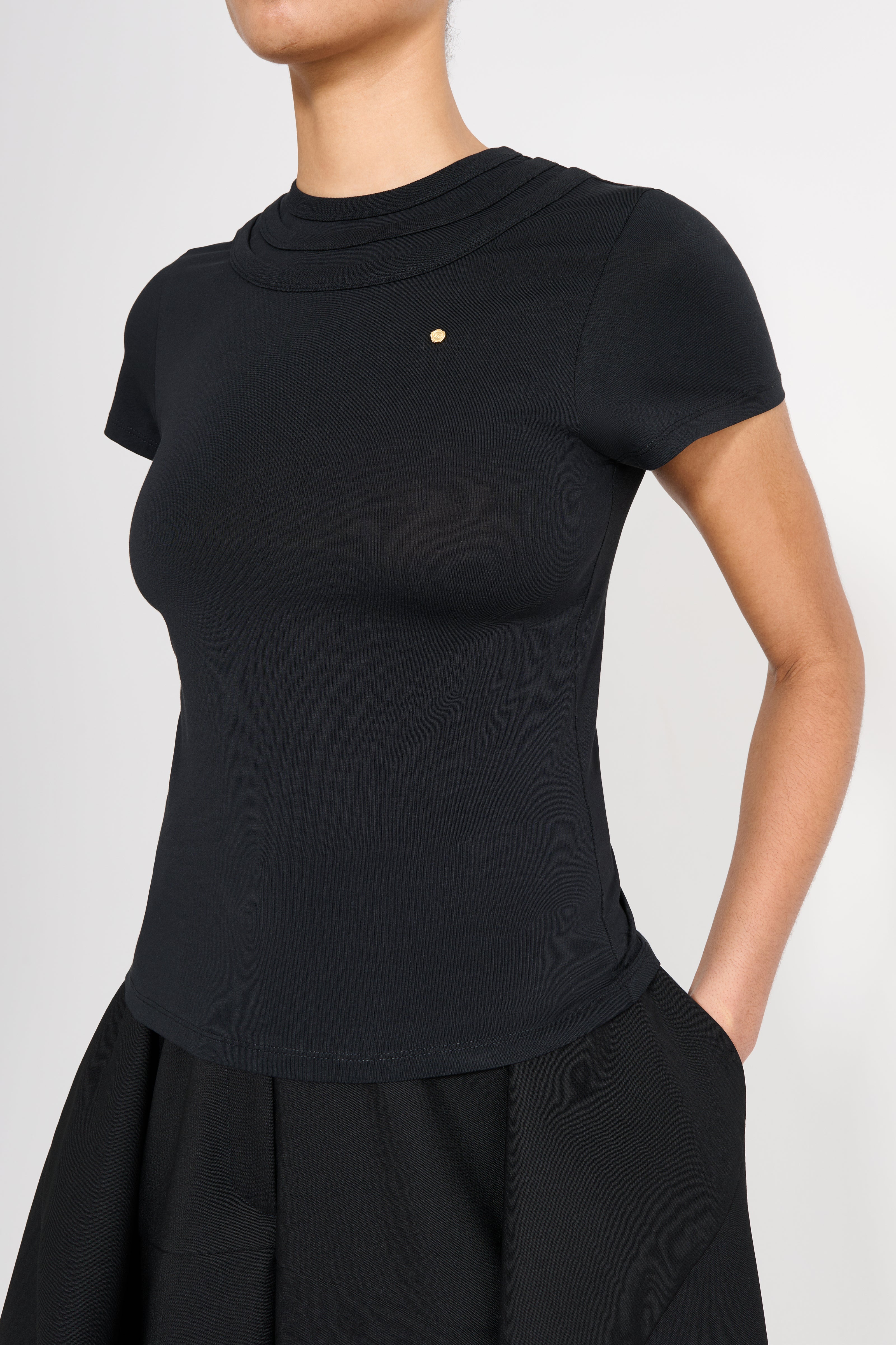 Black top worn by a person on a light gray background