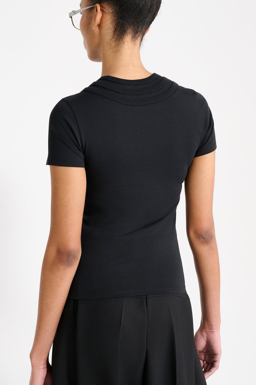 Person wearing a black t-shirt and black pants on a white background