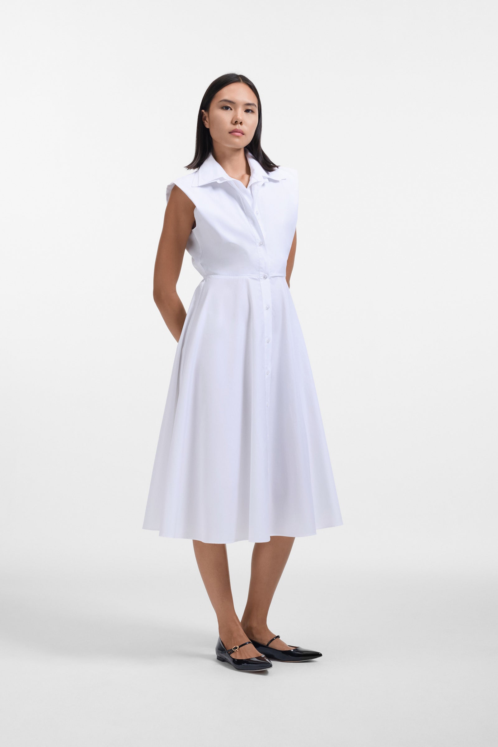 Model wearing a white shirt dress with a multi-layer collar on a withe background.