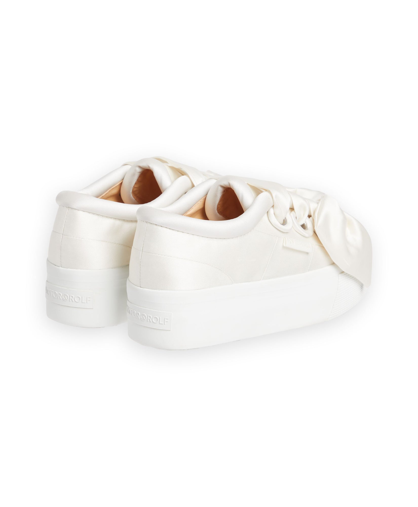 Elegant satin sneakers with oversized bows, featuring a smooth, pearl-like finish and elevated platform soles.