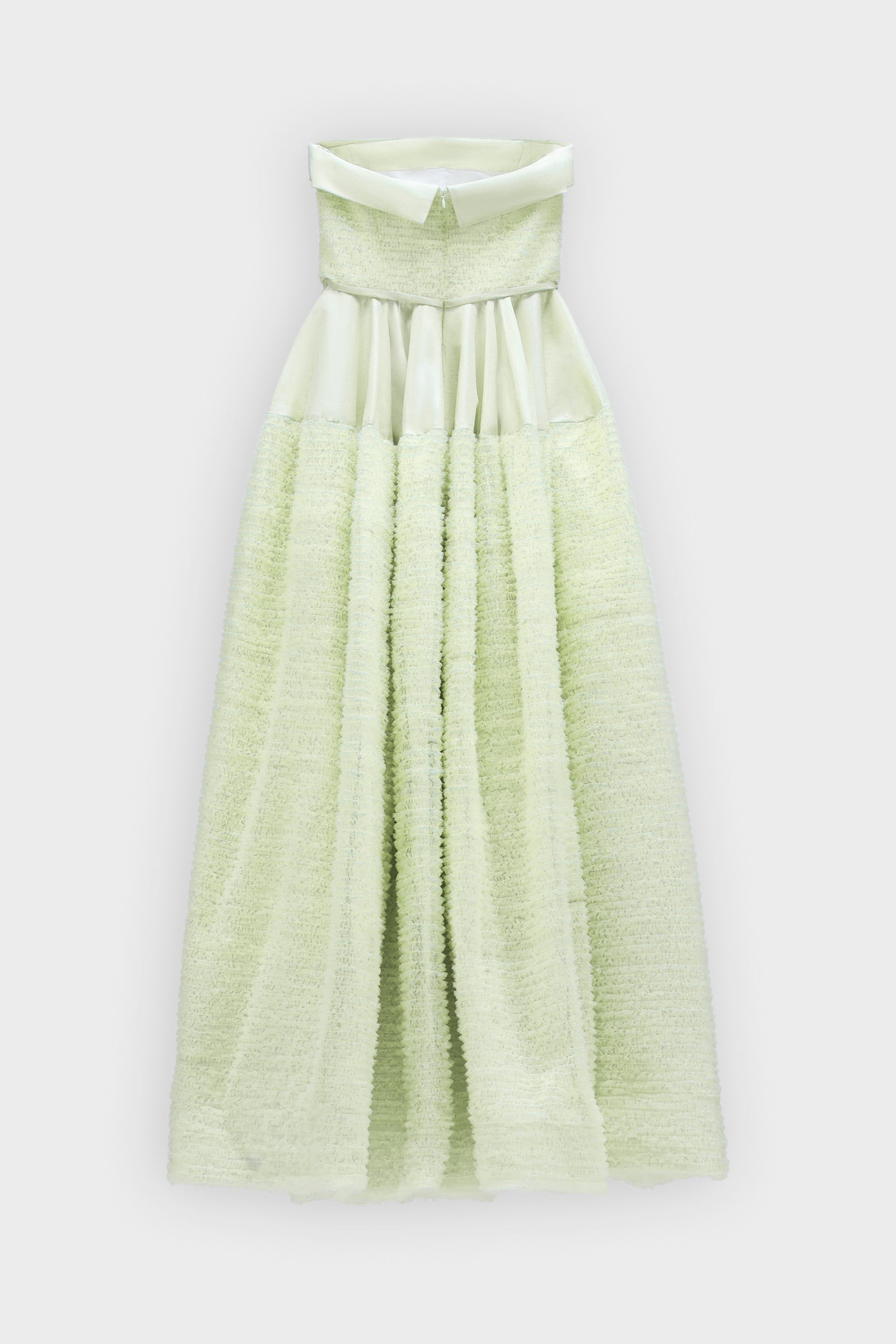 A mint green strapless tulle gown on a white background.