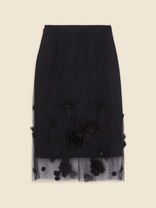 Elegant black skirt adorned with intricate floral appliqués and layered tulle, offering a chic and sophisticated look.