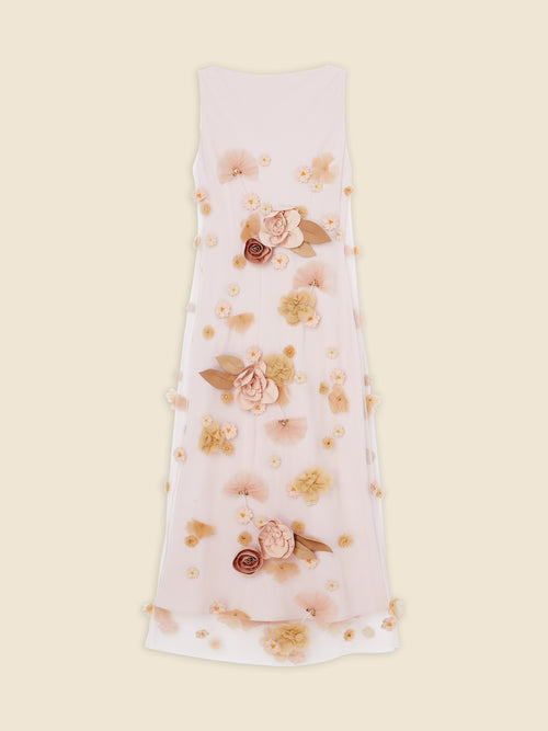 Sleeveless dress features intricate floral 3D appliqués in soft peach tones, elegantly arranged on a sheer white fabric.