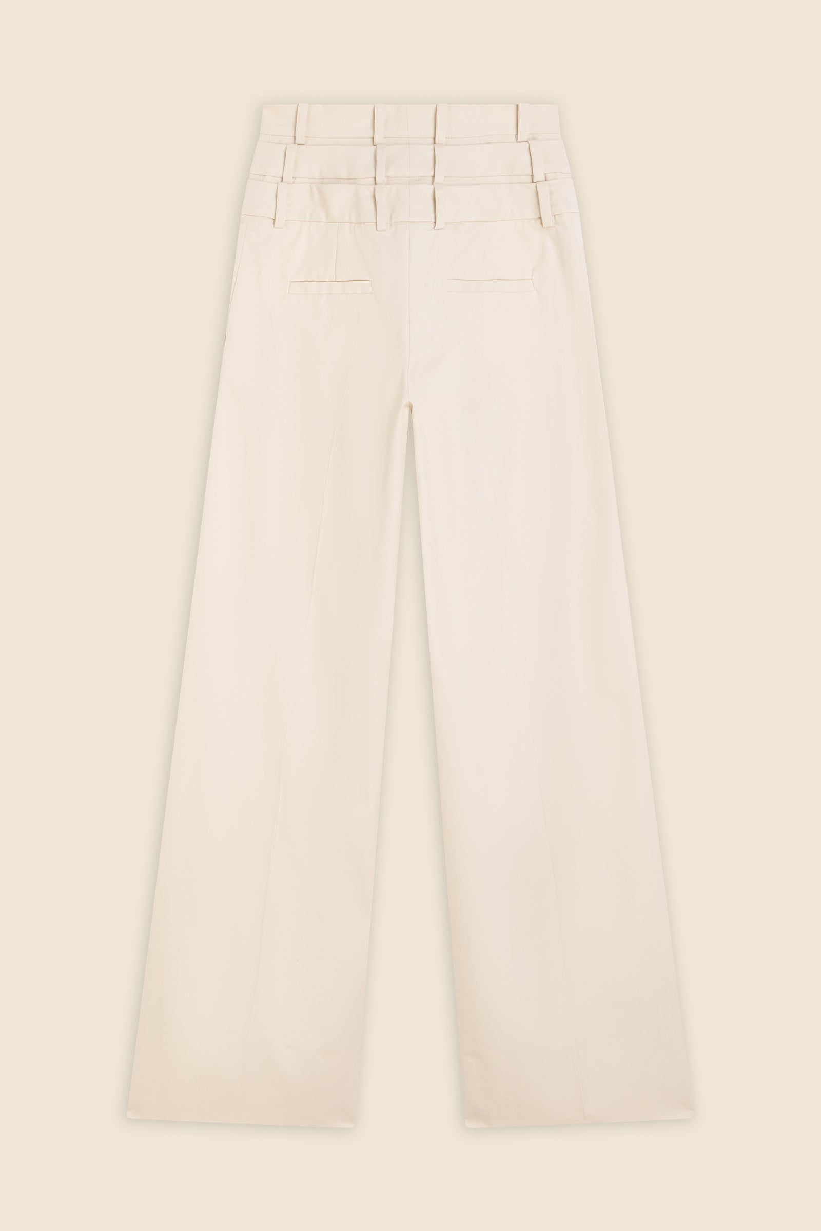 Beige multi-layer high waist trousers on a beige background.