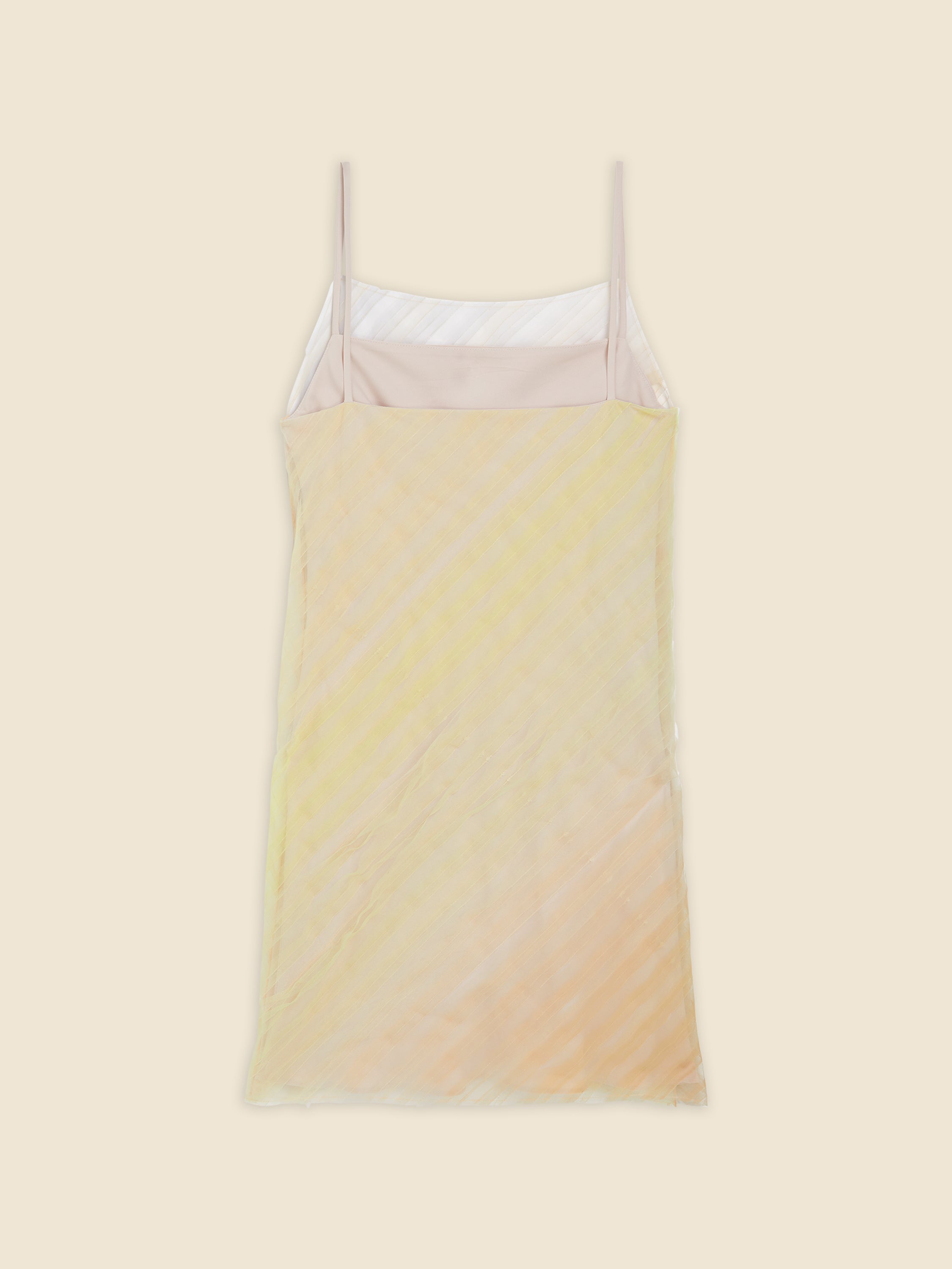 Pastel yellow and peach sheer slip dress with spaghetti straps displayed on a light beige background.