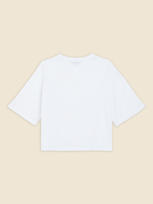 White cotton T-shirt with a relaxed fit, showcasing short sleeves and a round neckline, set against a neutral background.