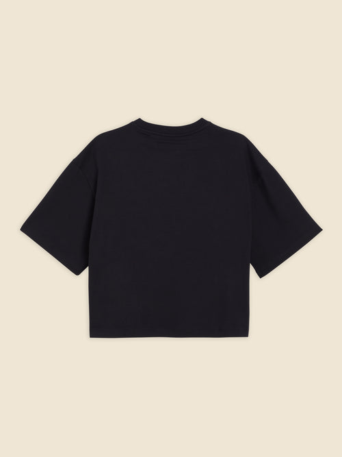 Black cotton oversized T-shirt with a minimalist design and short sleeves, offering a relaxed and contemporary fit.