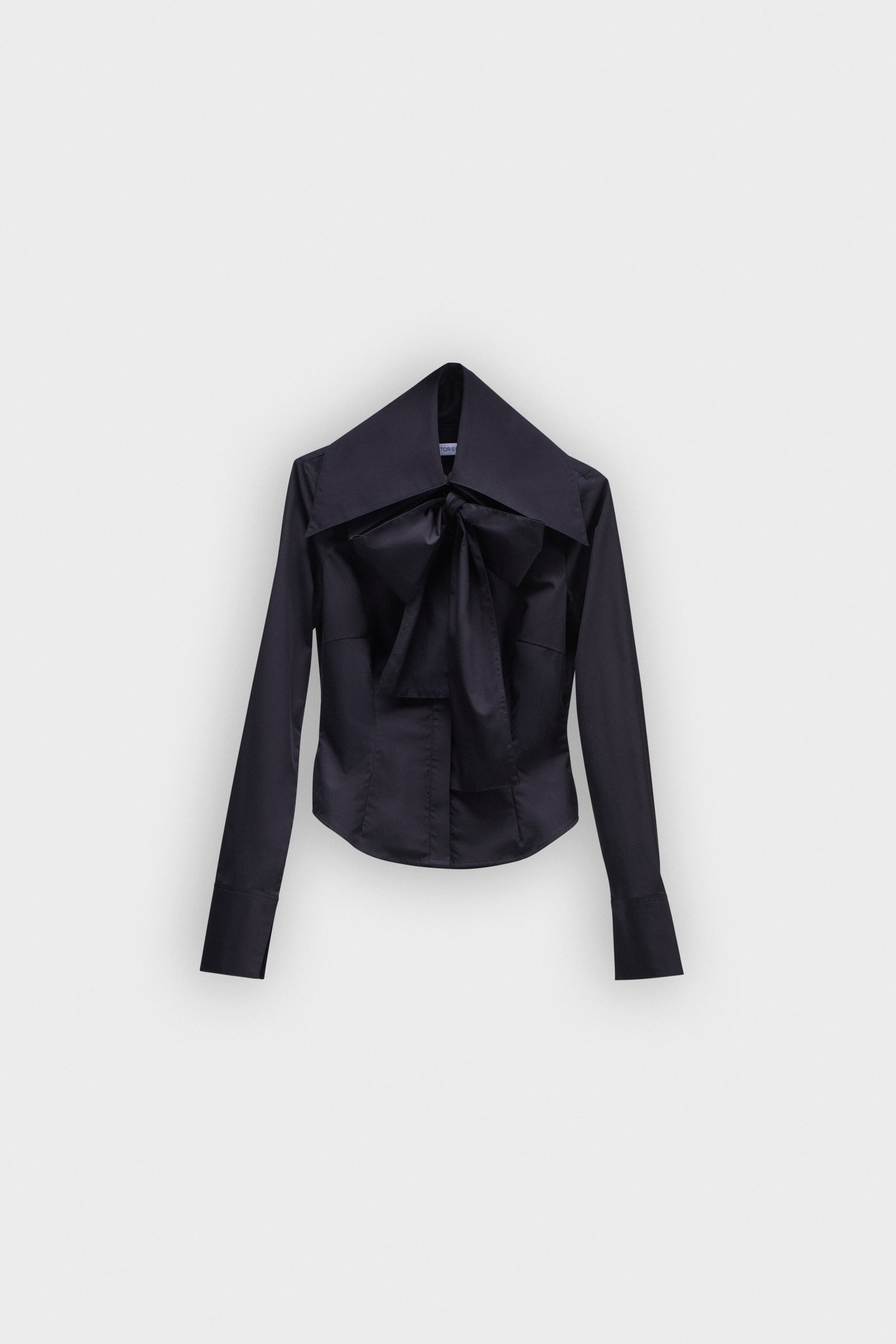 A black long sleeve shirt with a bow on the collar on a white background.