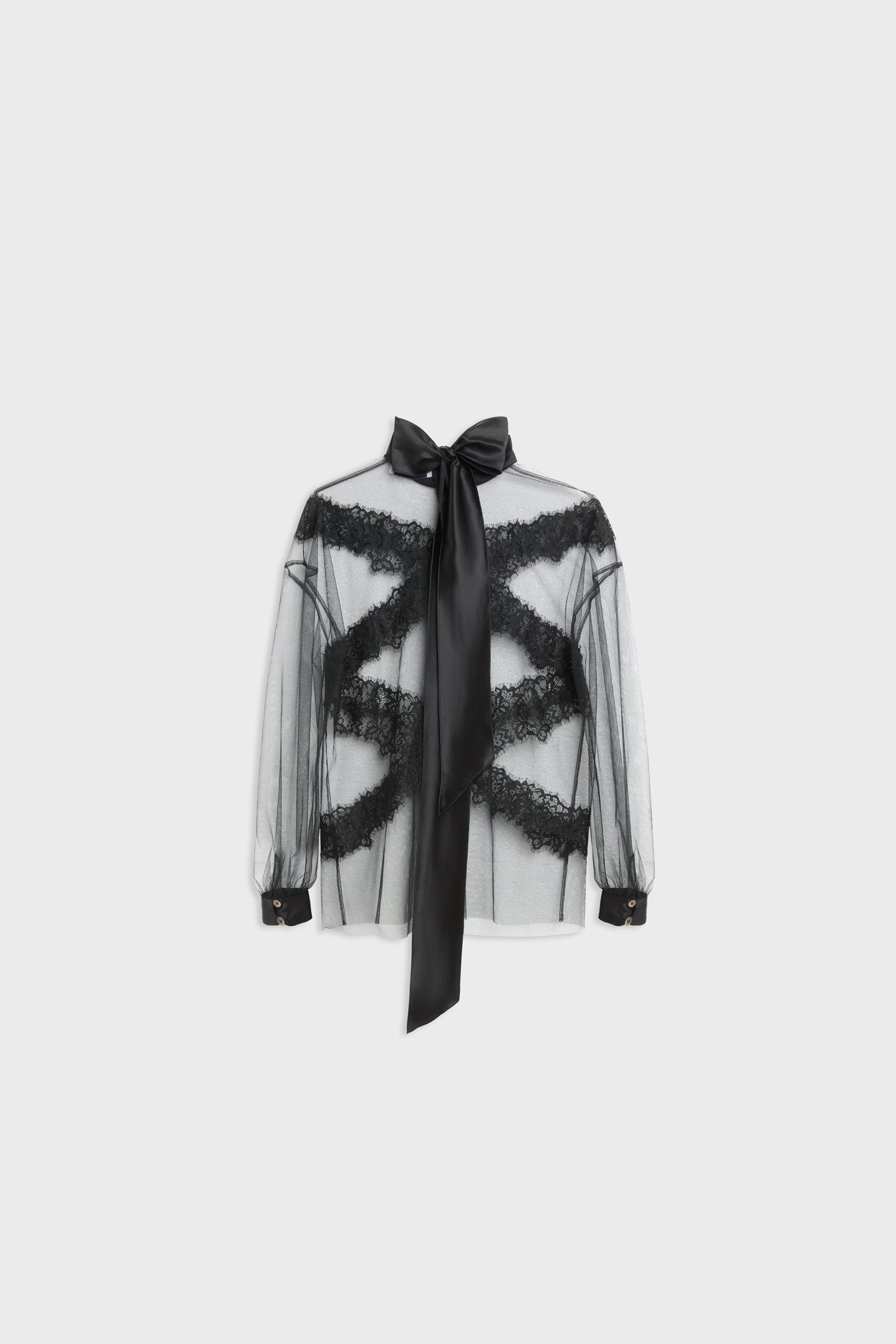 A sheer black long-sleeve blouse with black lace appliques and a matching black necktie bow, displayed on a neutral light gray background.