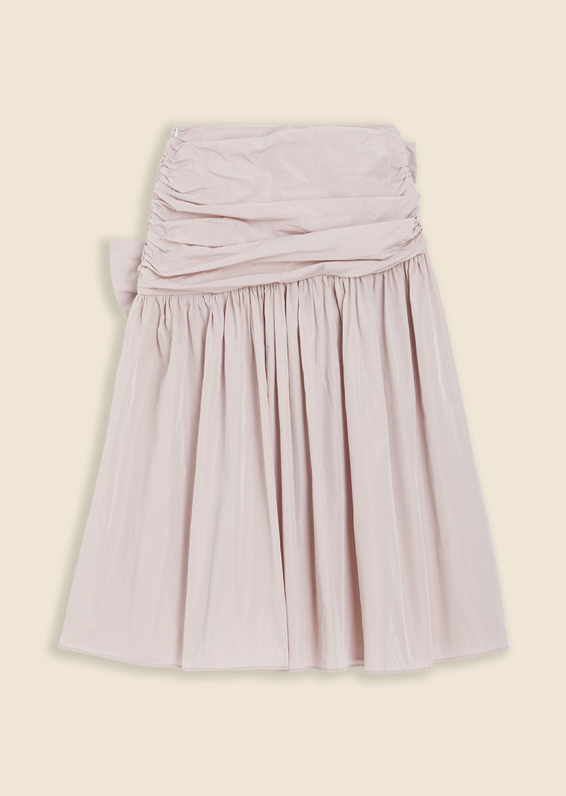Light pink ruched skirt with a high-waisted design and pleated fabric, adding elegant texture and volume to the outfit.