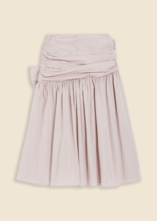 Light pink ruched skirt with a high-waisted design and pleated fabric, adding elegant texture and volume to the outfit.