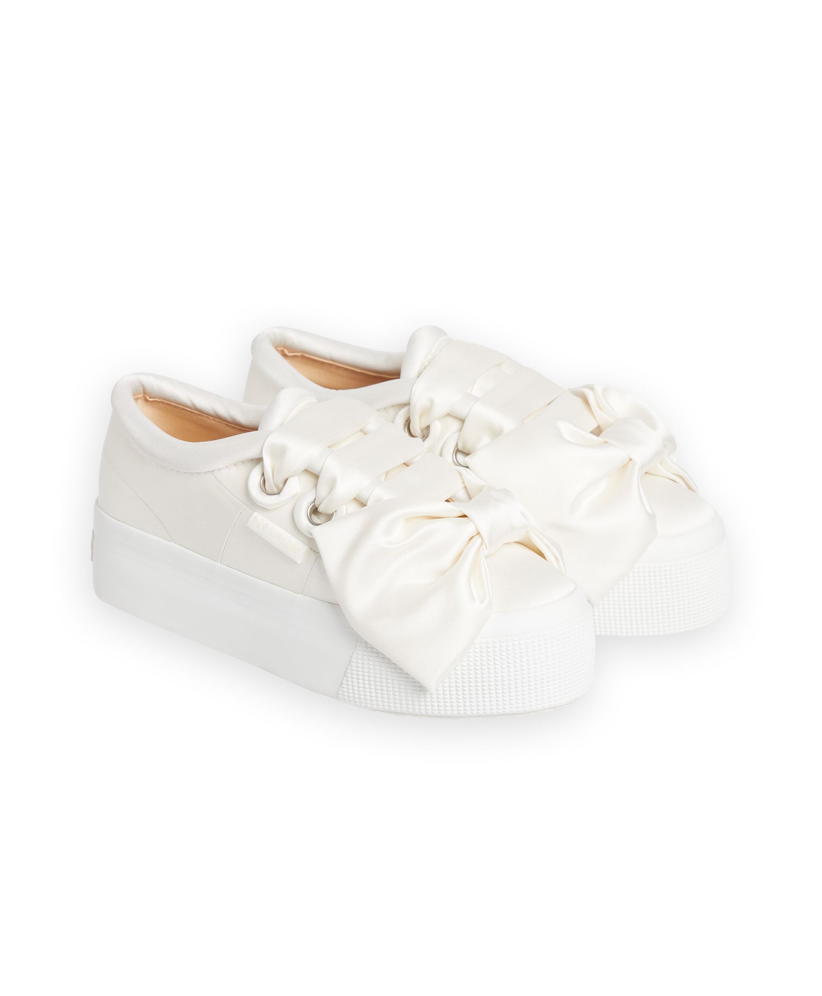 Elegant white sneakers featuring oversized satin bows, perfect for adding a touch of sophistication to casual outfits.