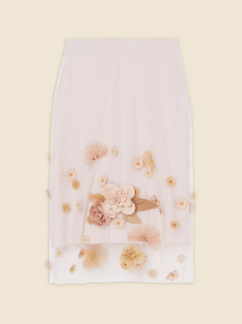 A white skirt adorned with intricate pastel flower appliqués, featuring layered petals and bead accents on a soft chiffon fabric.