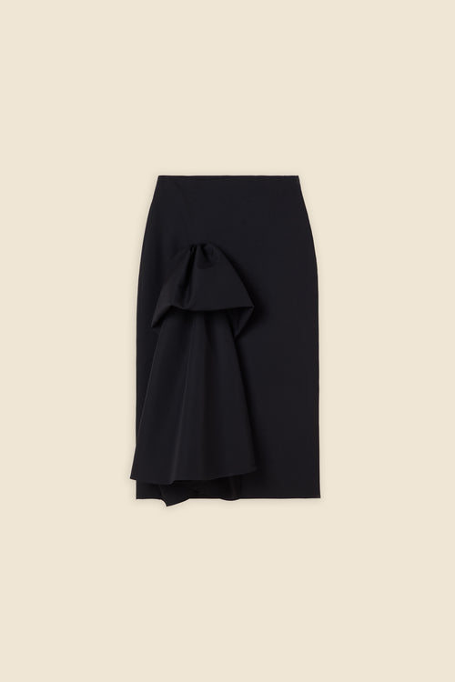 The craftmanship of the skirt reinterprets classic haute couture tuck ups into a modern silhouette from wool
